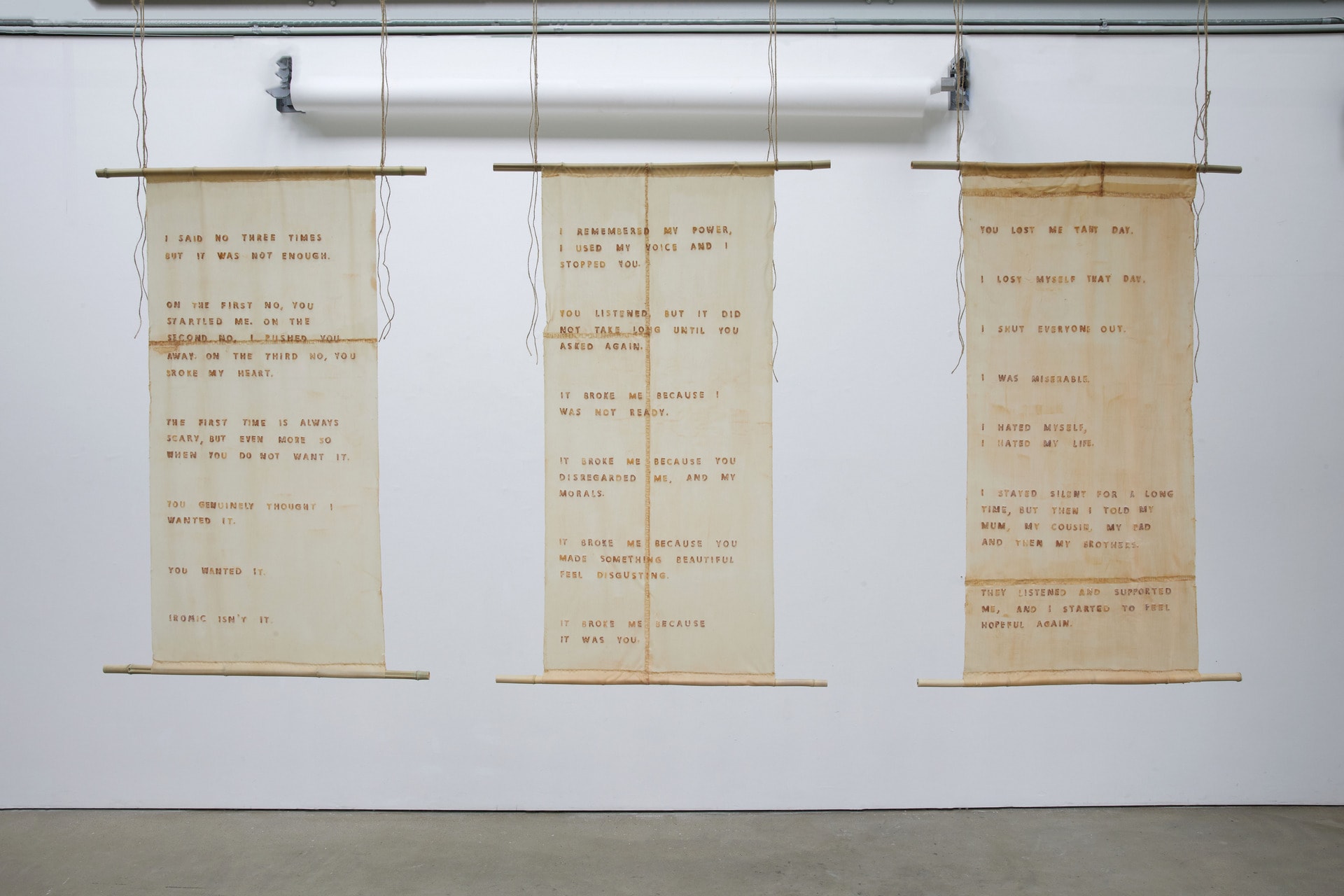 Three latext scrolls narrating a womens first encounter of sex, hung on bamboo using hemp rope.