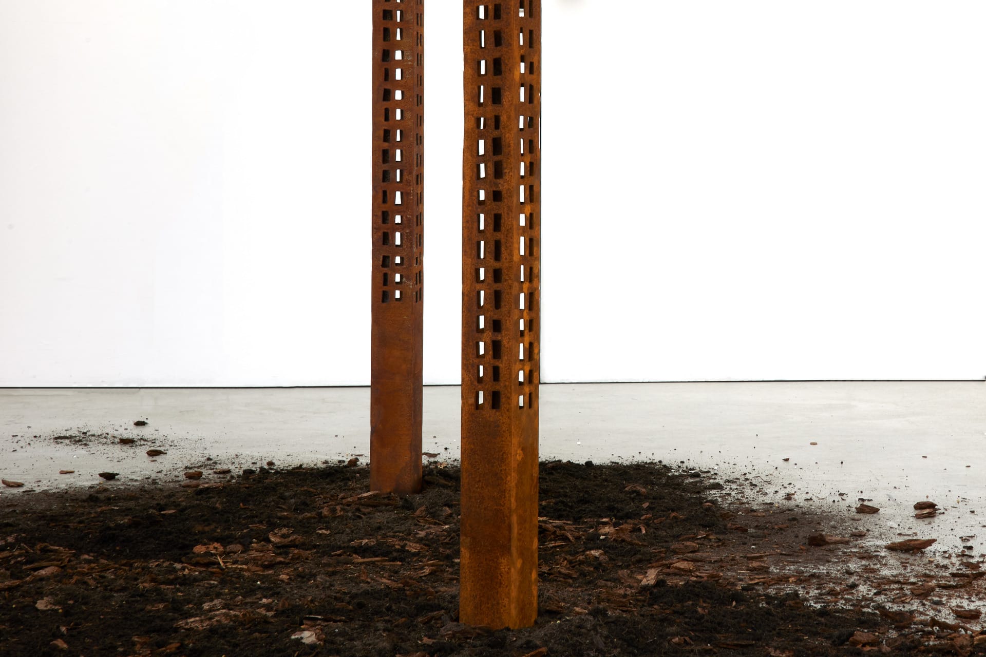 seven rusted stell towering skyscrapers that rise out of scattered earth