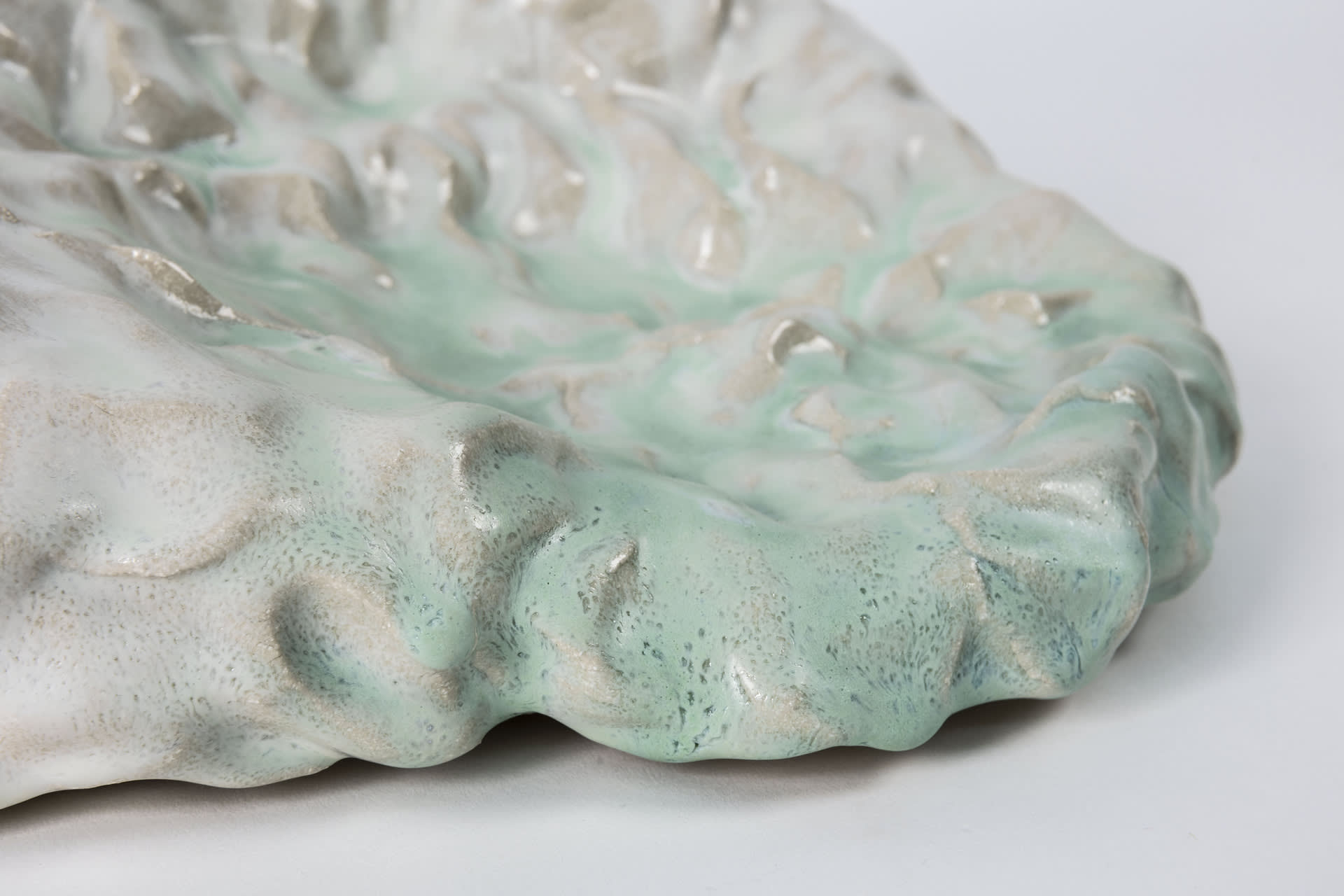 Detail closeup. Pooling glaze in mint green and white. Ceramic 