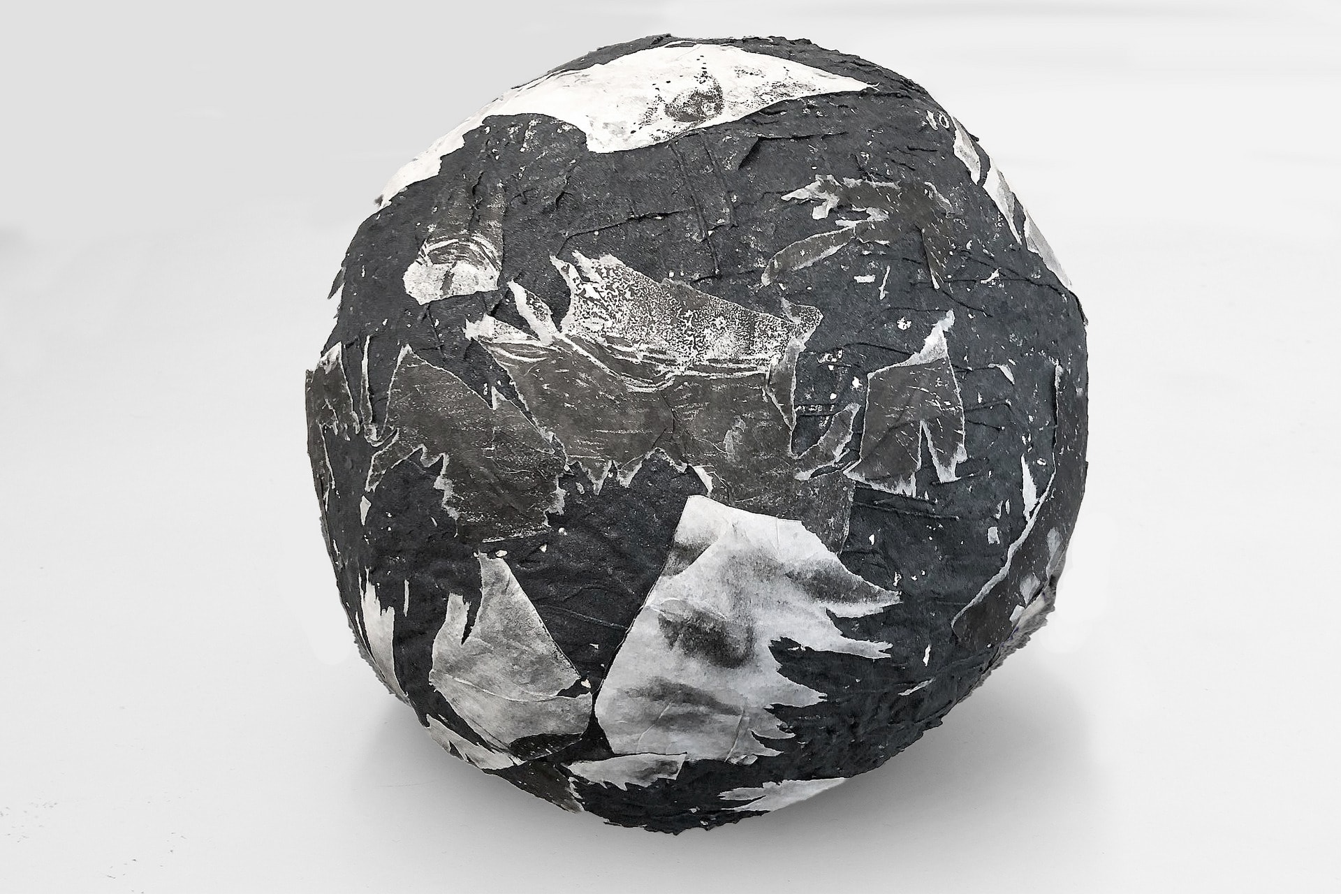 Ascension IV, a carborundum boulder of 60cm in diameter with lithographs of body parts on its surface