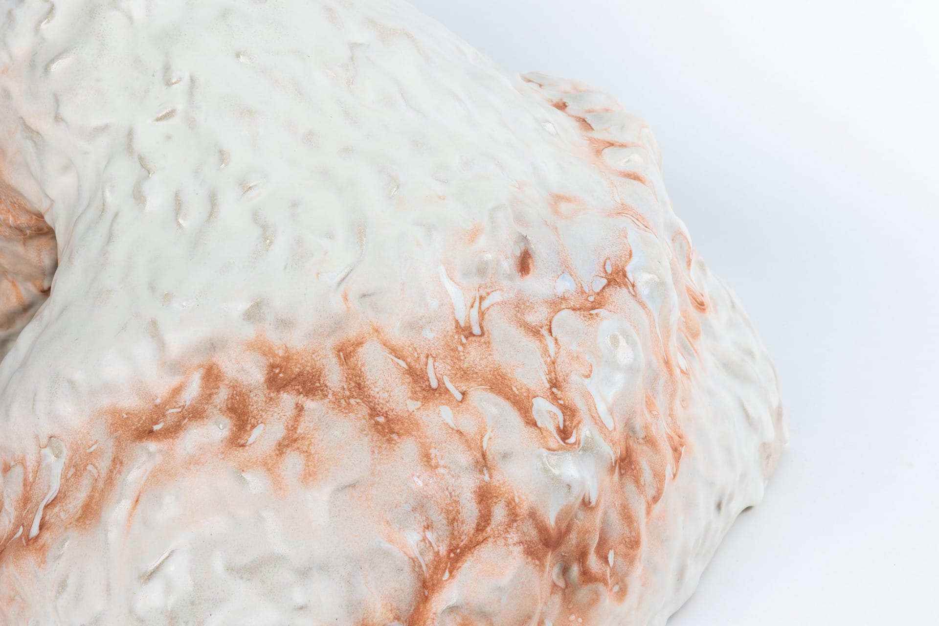 Tactile large scale ceramic piece in orange and white.  Colours flowing together. Anthropomorphic figure, detail