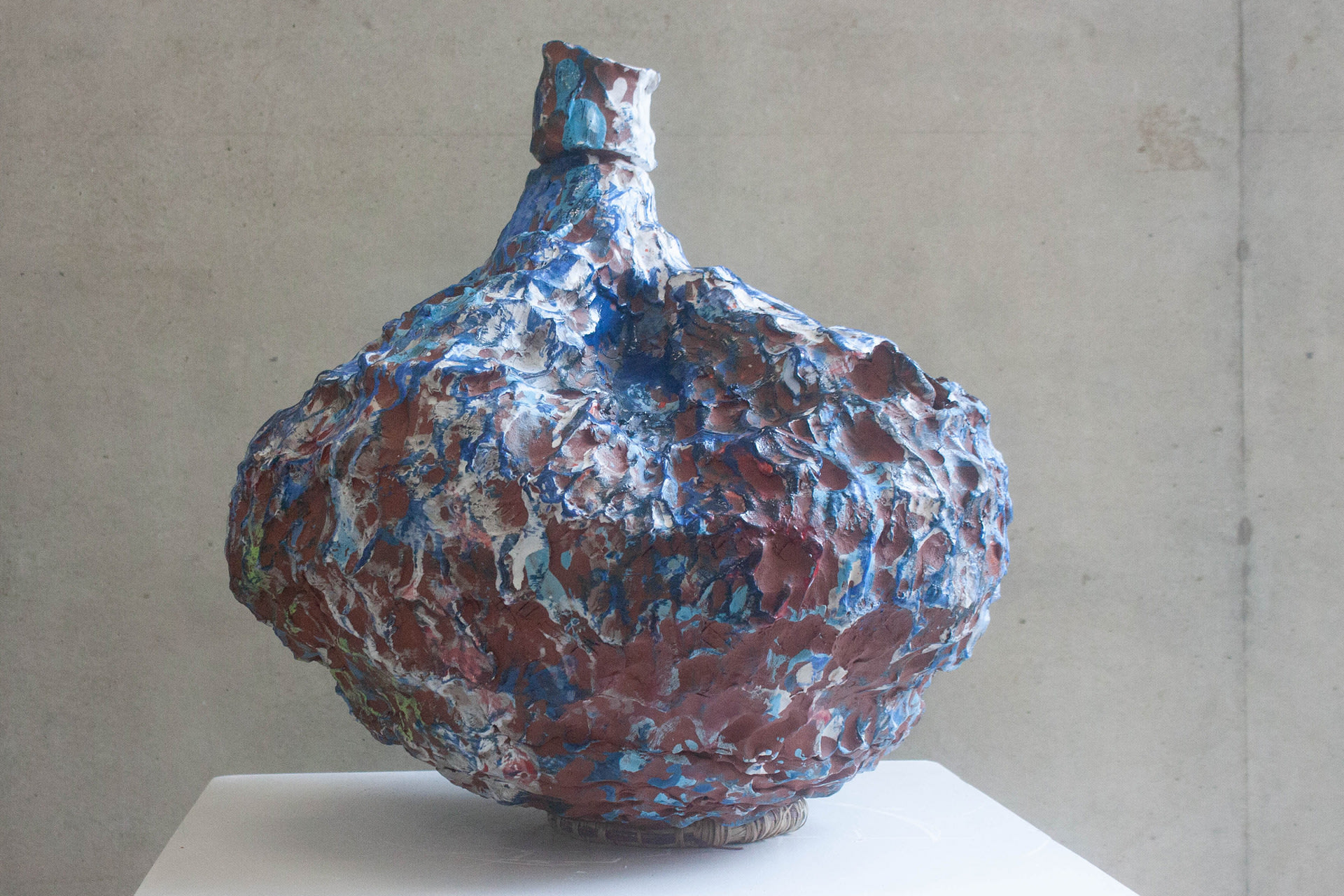 reverse view of wide based sculptural pot with narrow neck described above - blue, white and areas of red colouring