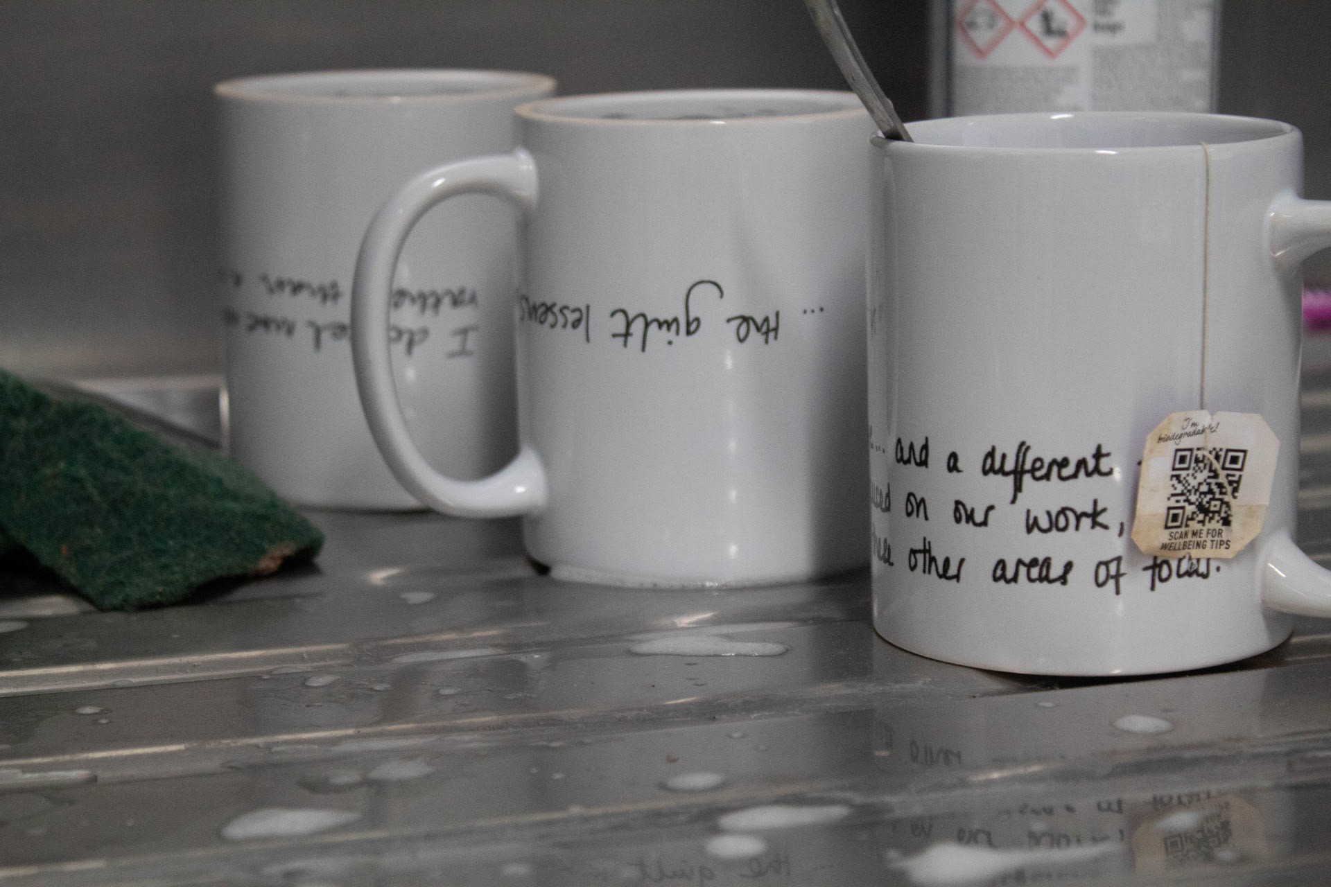 mugs next to a sink  writing says the guilt lessens and part of a sentence on the other mug