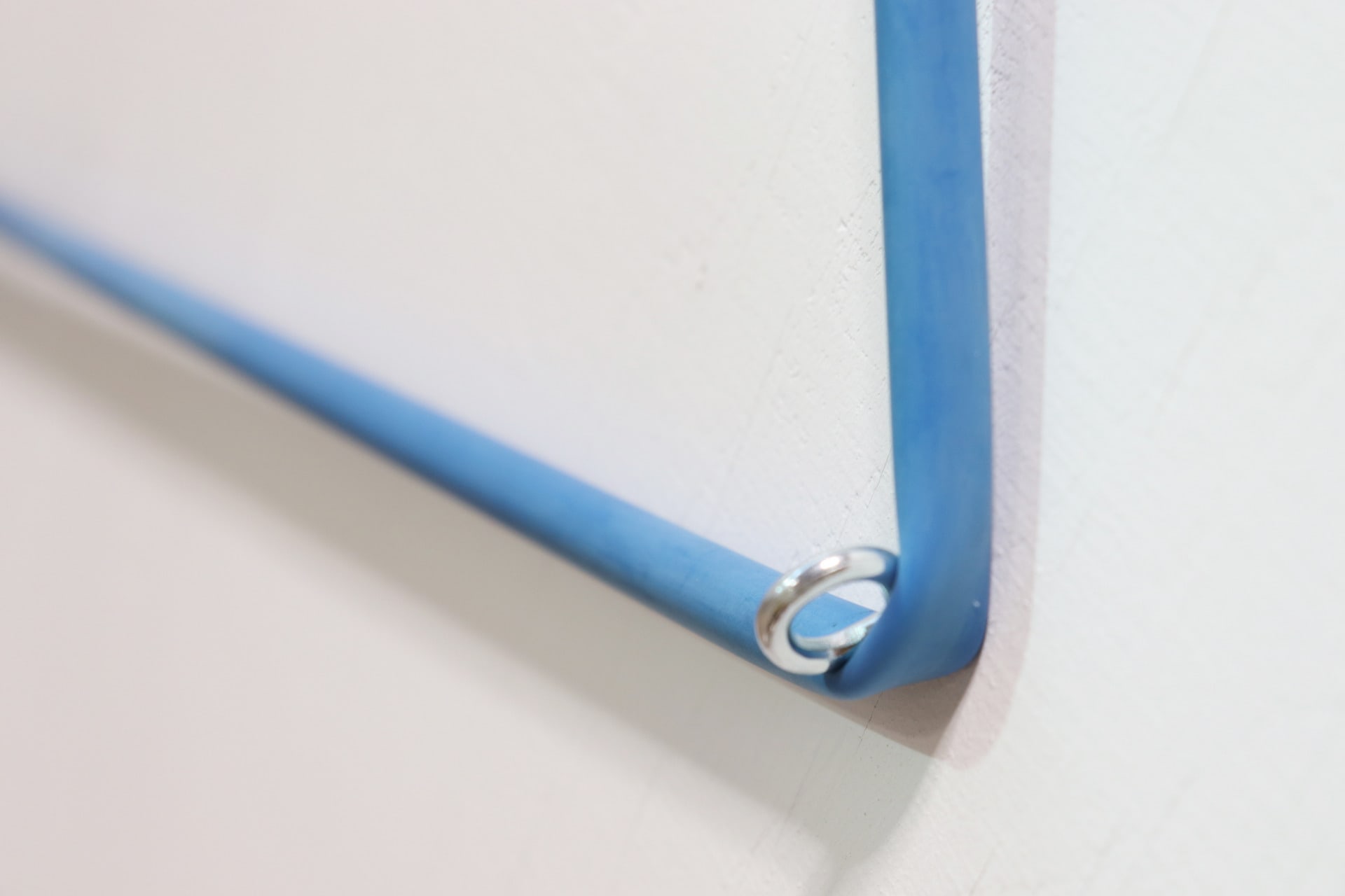 Rubber resistance band tautly suspended over a hook on wall