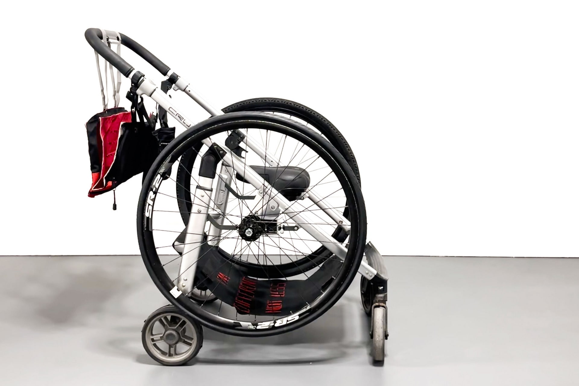 side view of the object, highlighting the bicycle wheels, that in their current position, resemble wheelchair wheels