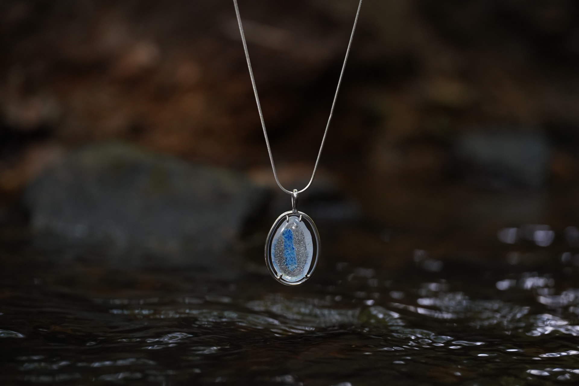 A glass pebble made with caddisfly and local crafters.