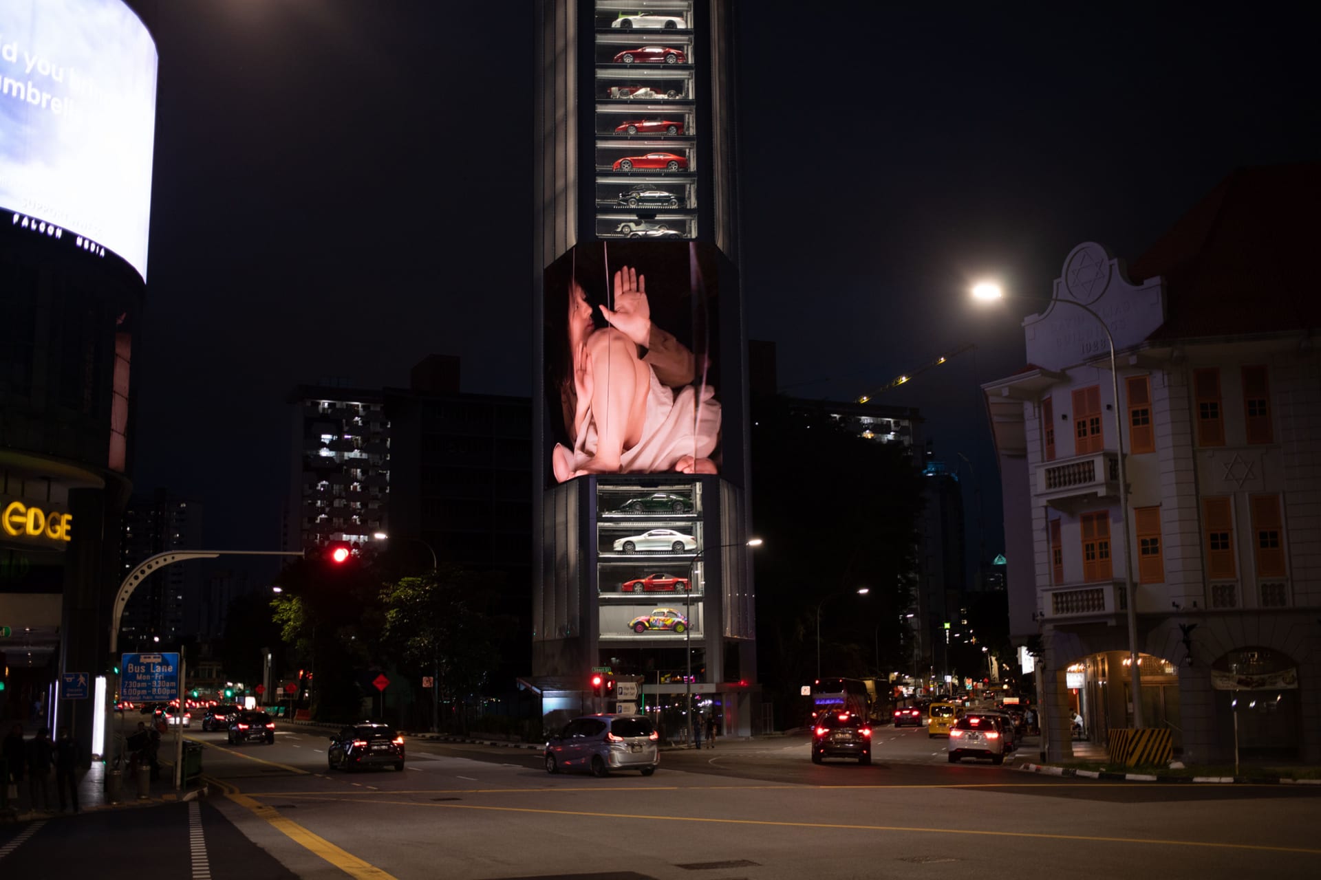 Box Body: A giant human inside a box on a large LED screen on a tall building in Singapore.