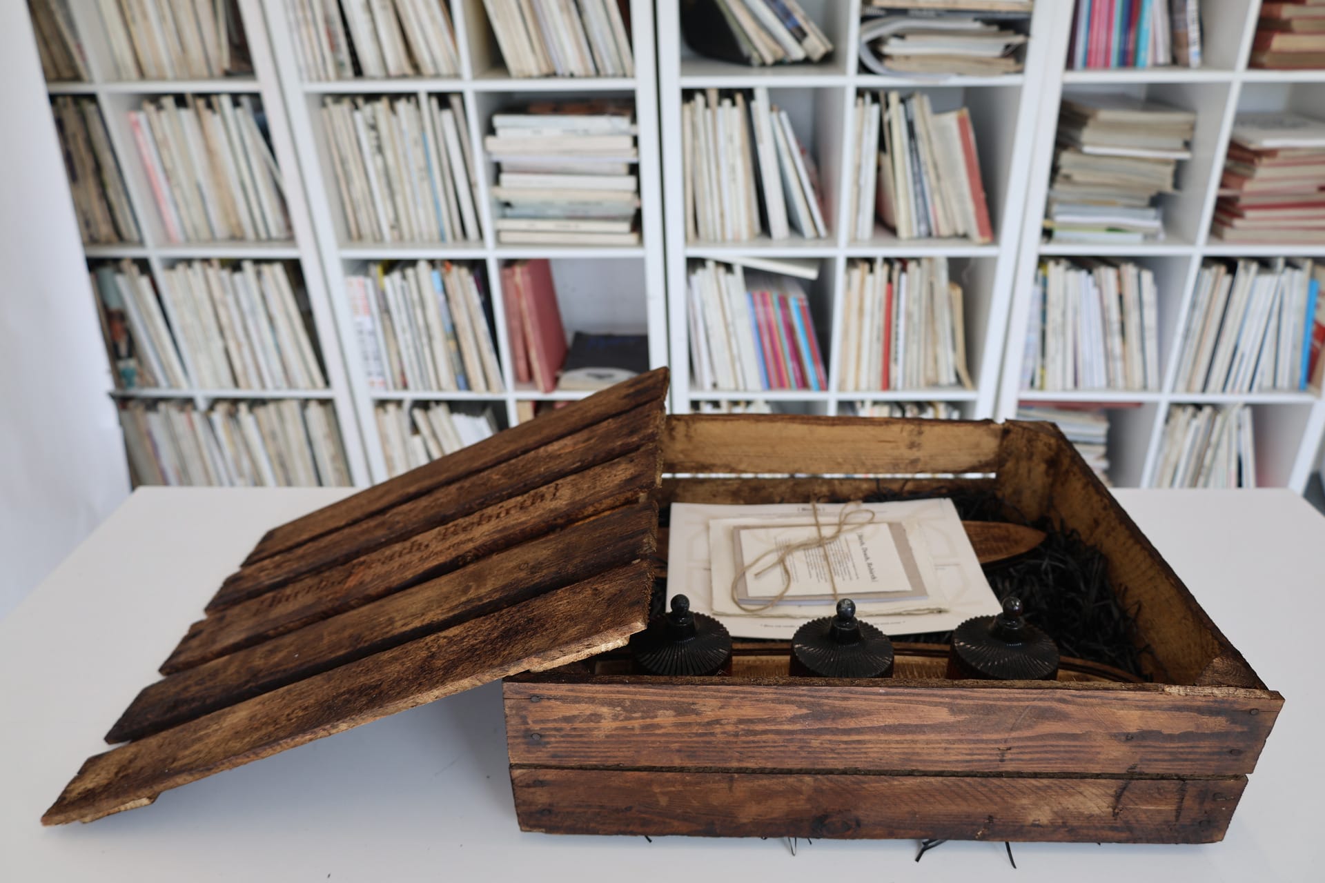 a wooden box, tray and candles arranged on table.