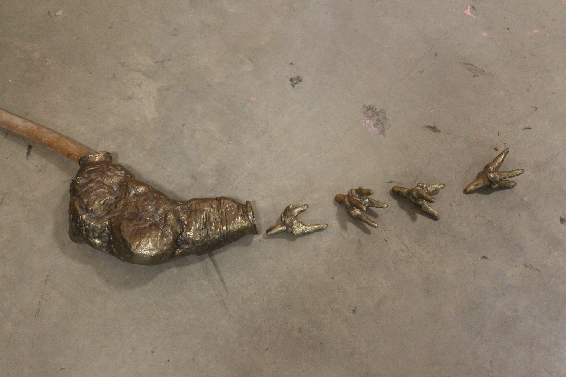 close up photo of a organ shaped vessel with four teeth like small bronze parts placed to be spilling out of one end 