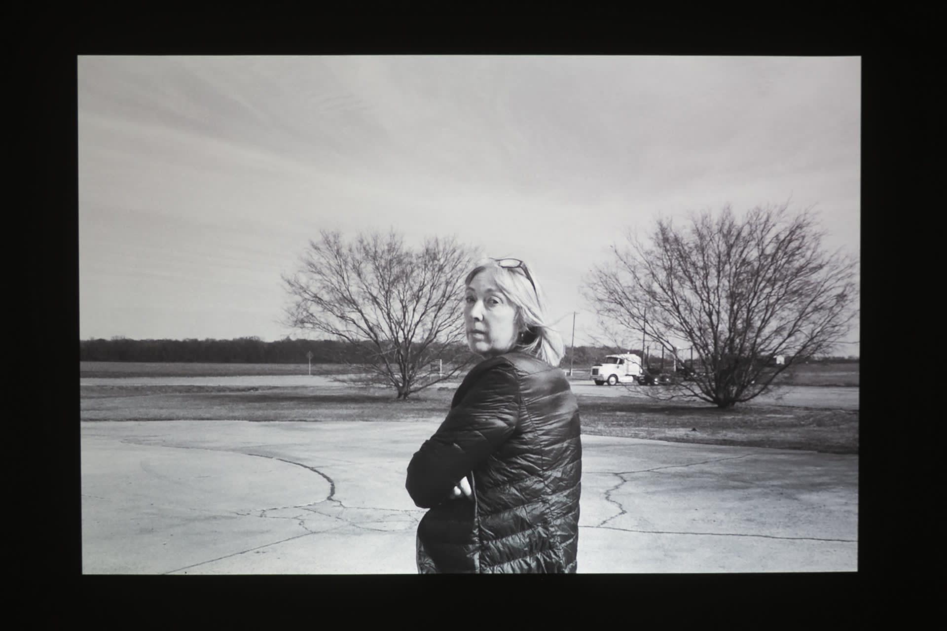 Woman in Black and White looking over shoulder back to the camera with annoyed face and arms crossed.