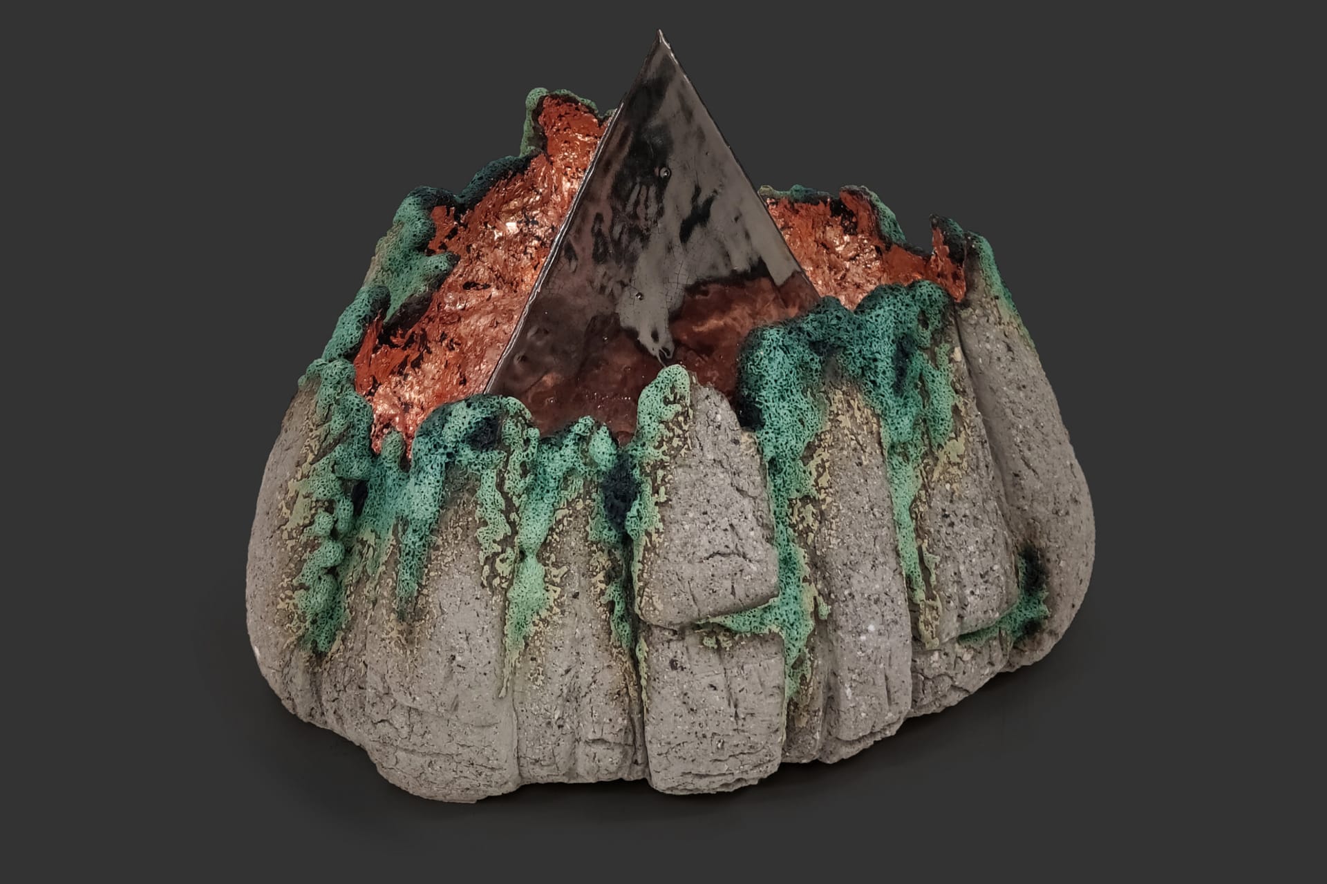 An image of ceramic sculpture by Chloe Lennon with metal copper leaf and volcanic glazes representing nature and industry. 