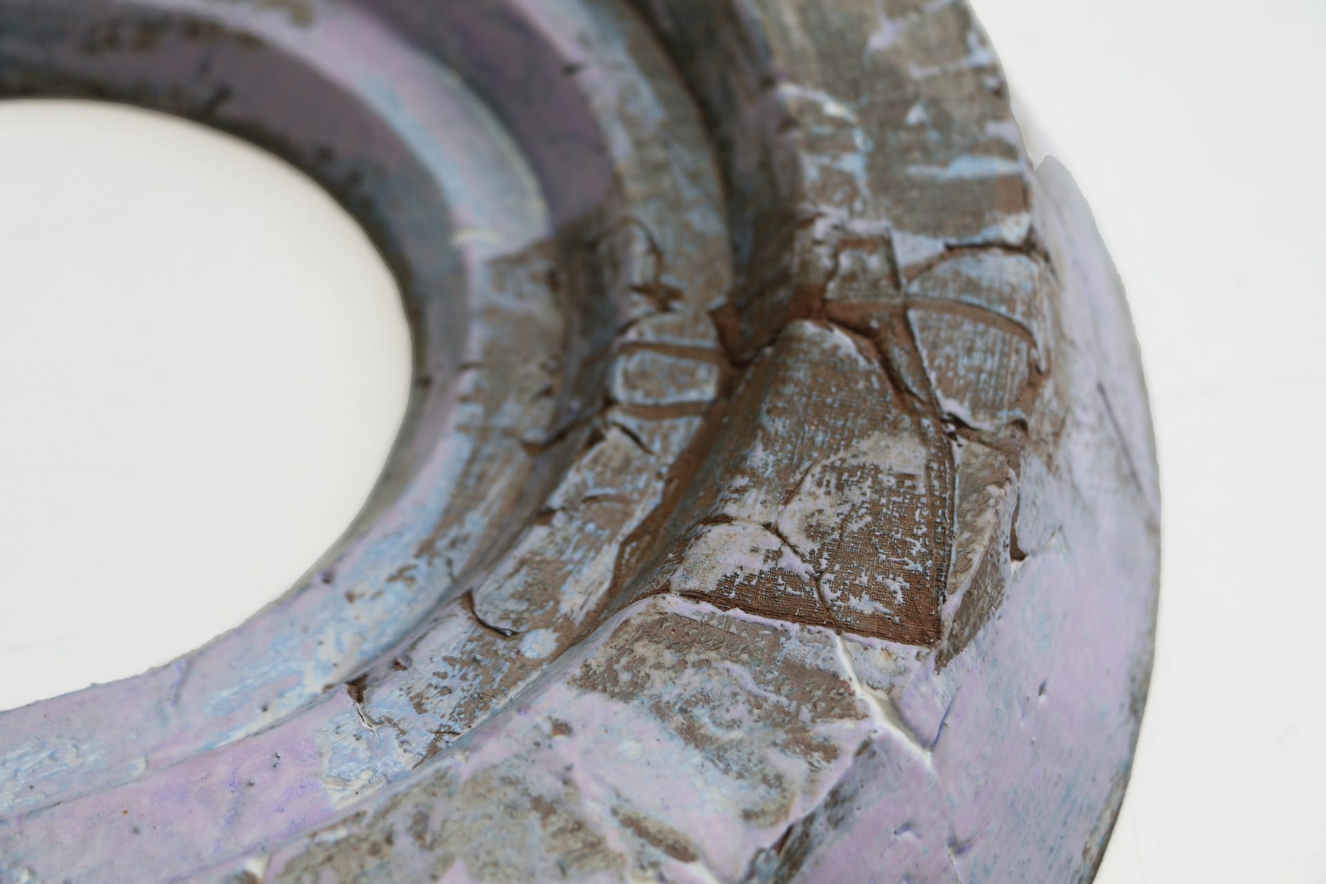 Close up of Purple oval ceramic, textured with findings from walks, small jewellery bag 