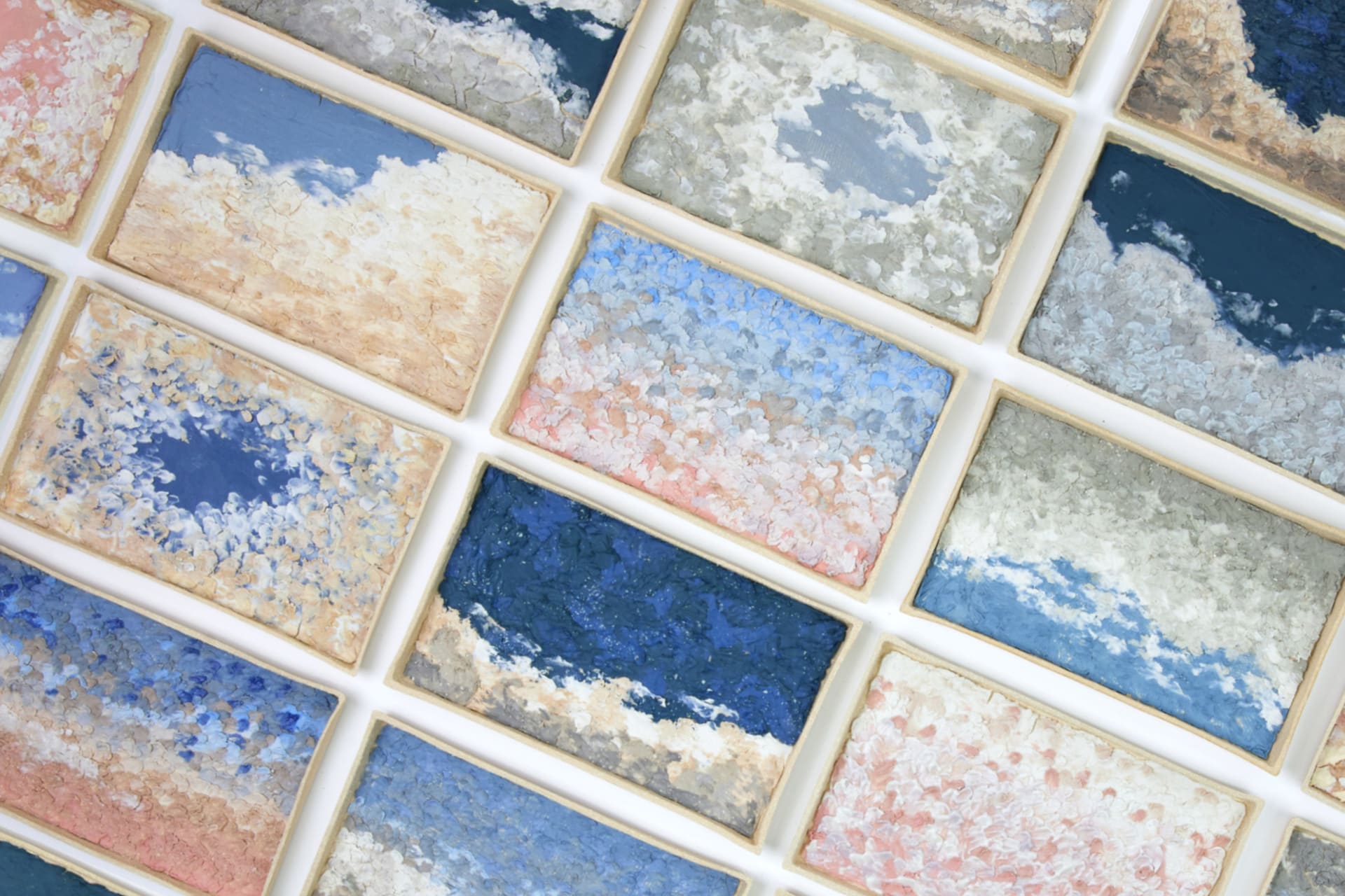 multiple ceramic pieces inspired by sky scenes with various colours and textures.