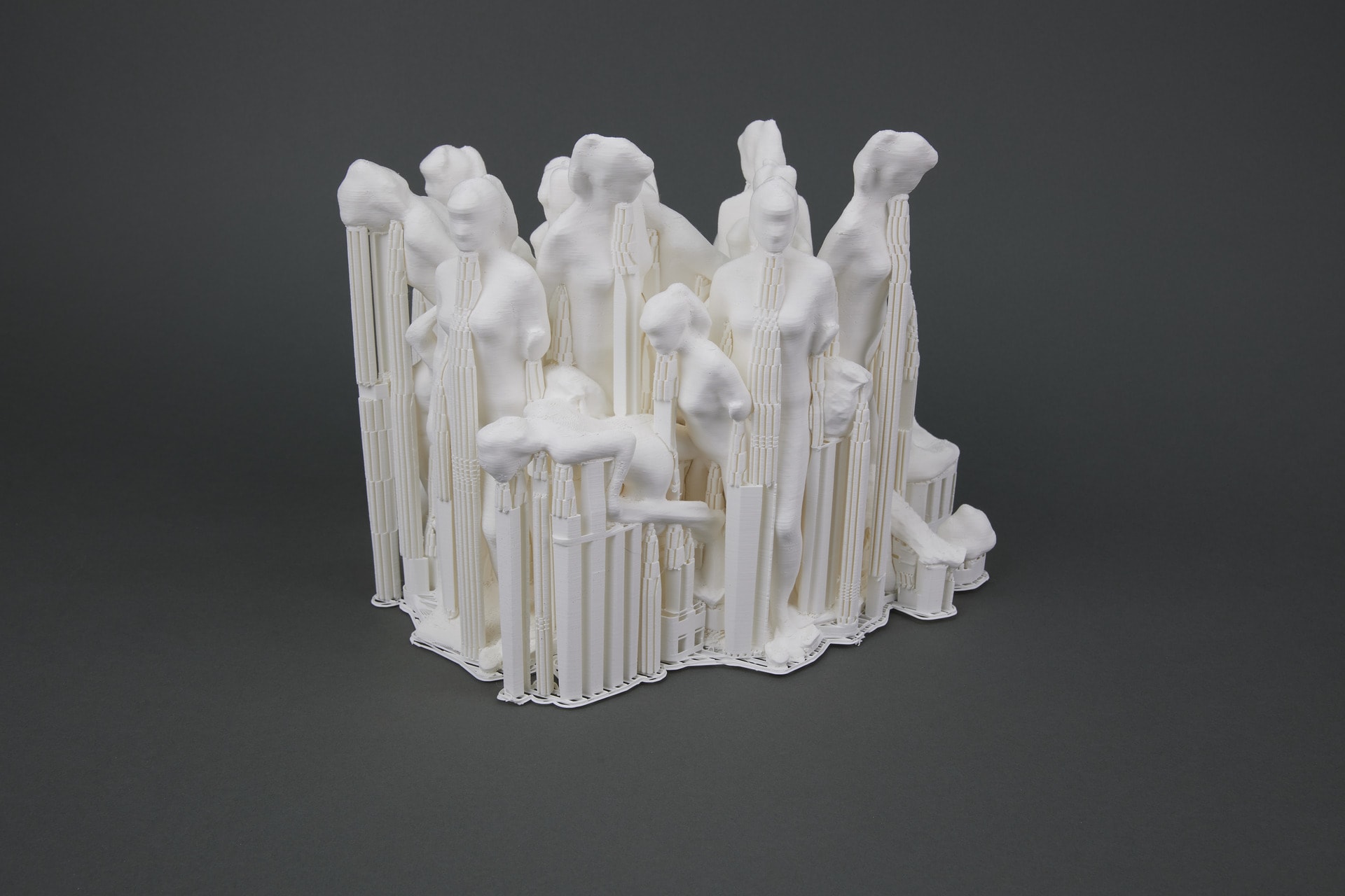 3D Printed sculpture of female figures supported by each other, scaffolding and drapery.