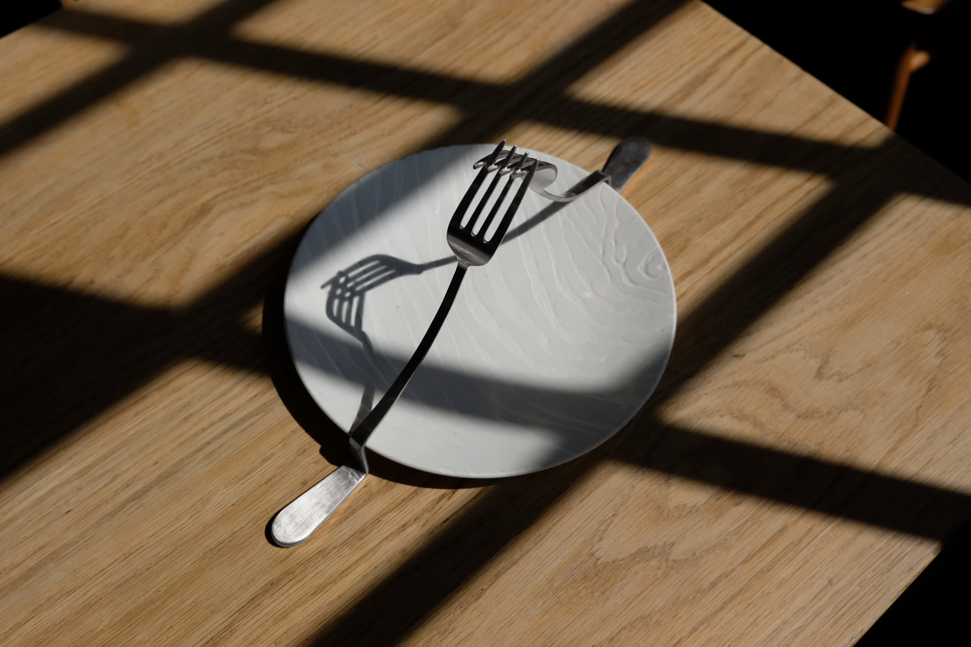 two elongated forks fighting each other over a large plate with zebra carving