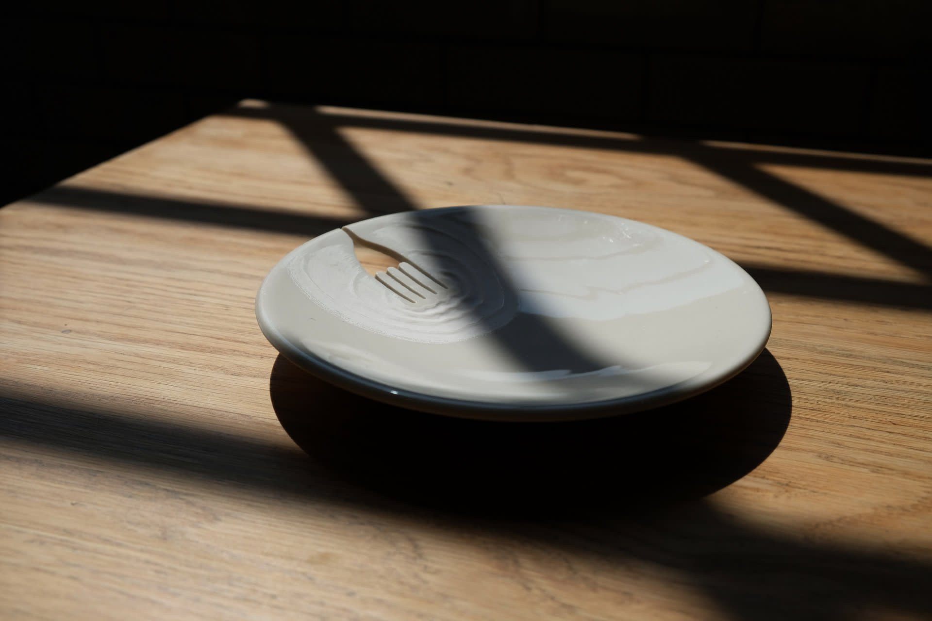 a ceramic plate with a fork shape carved into, with carved ripples