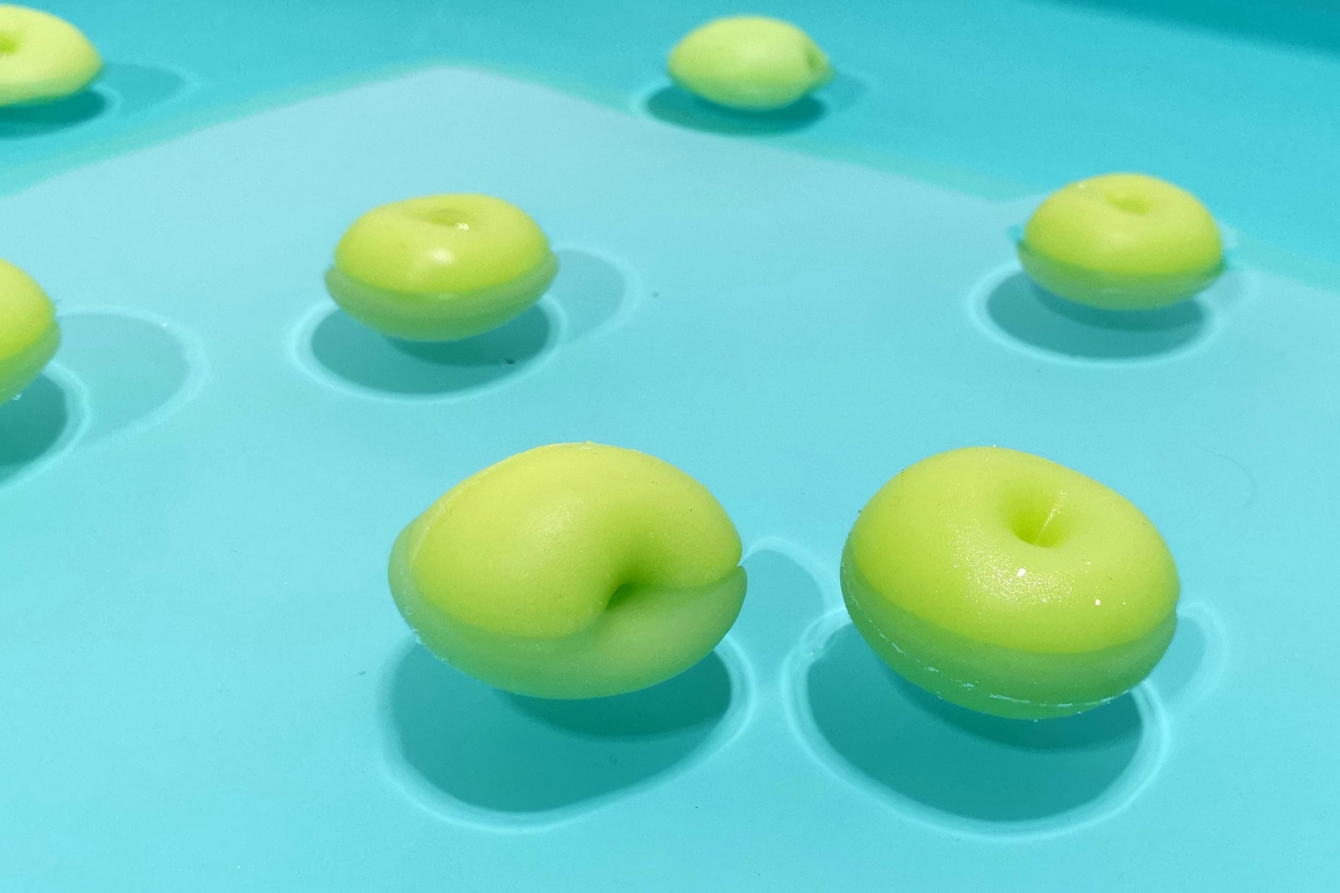 Casts of apples floating in a blue pool