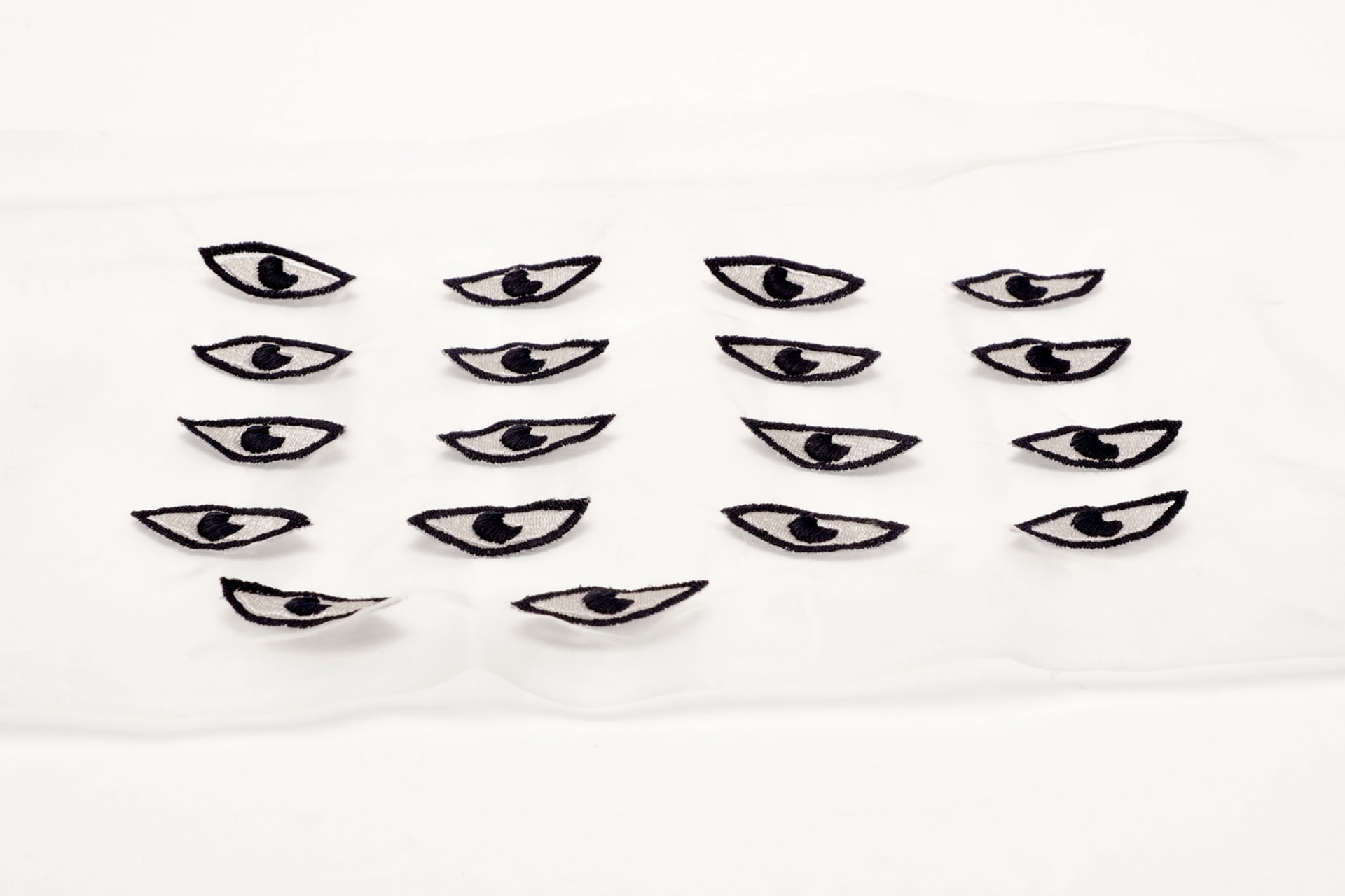 Illustrated eyes embroidered on silk material; inspired by the humanisation of objects and the objectification of humans.