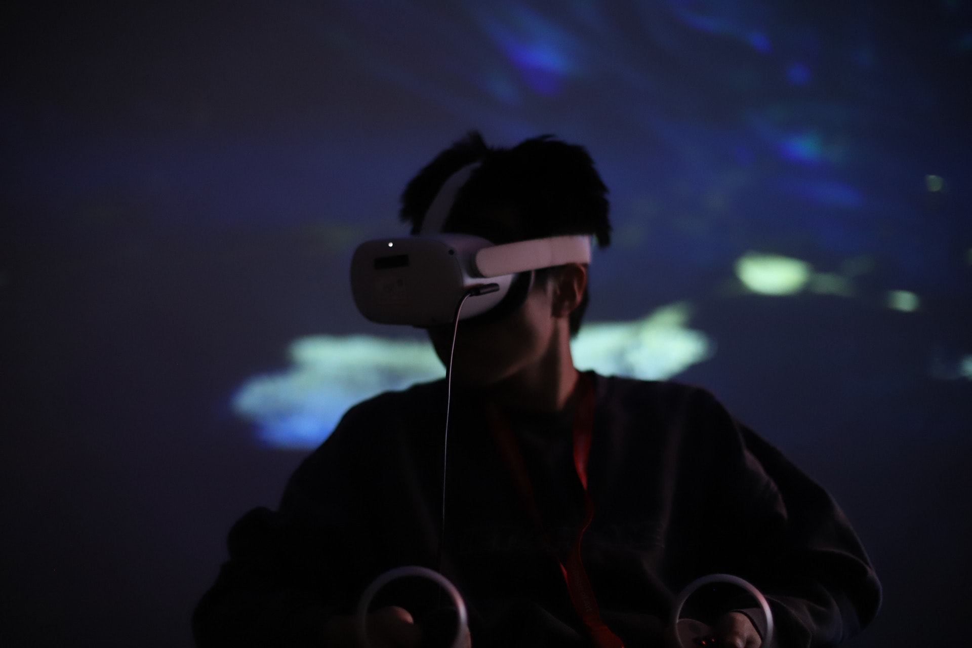 Participant experiencing our immersive headset VR experience with projected visuals in the background