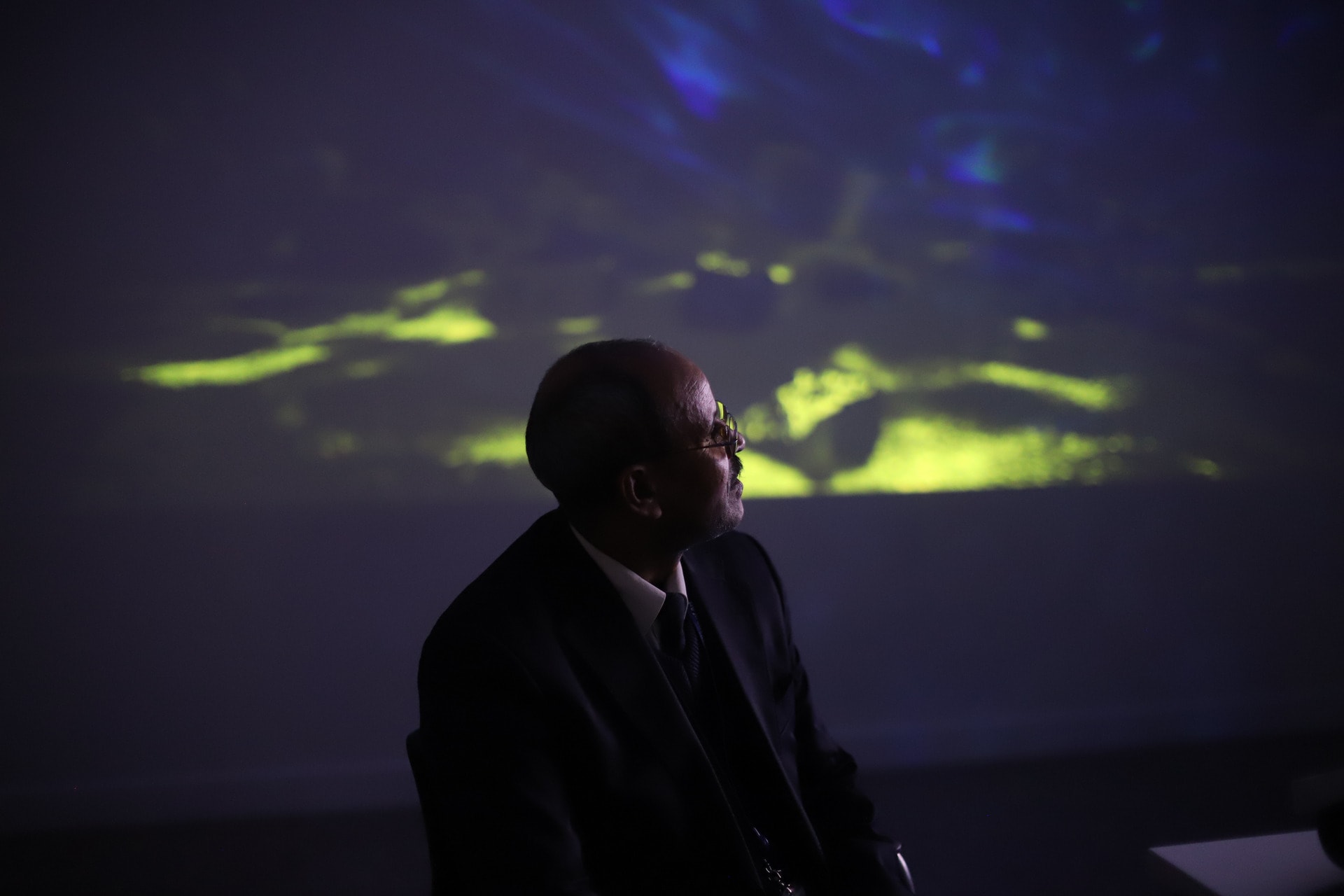 Participant experiencing our immersive experience with projected visuals in the background