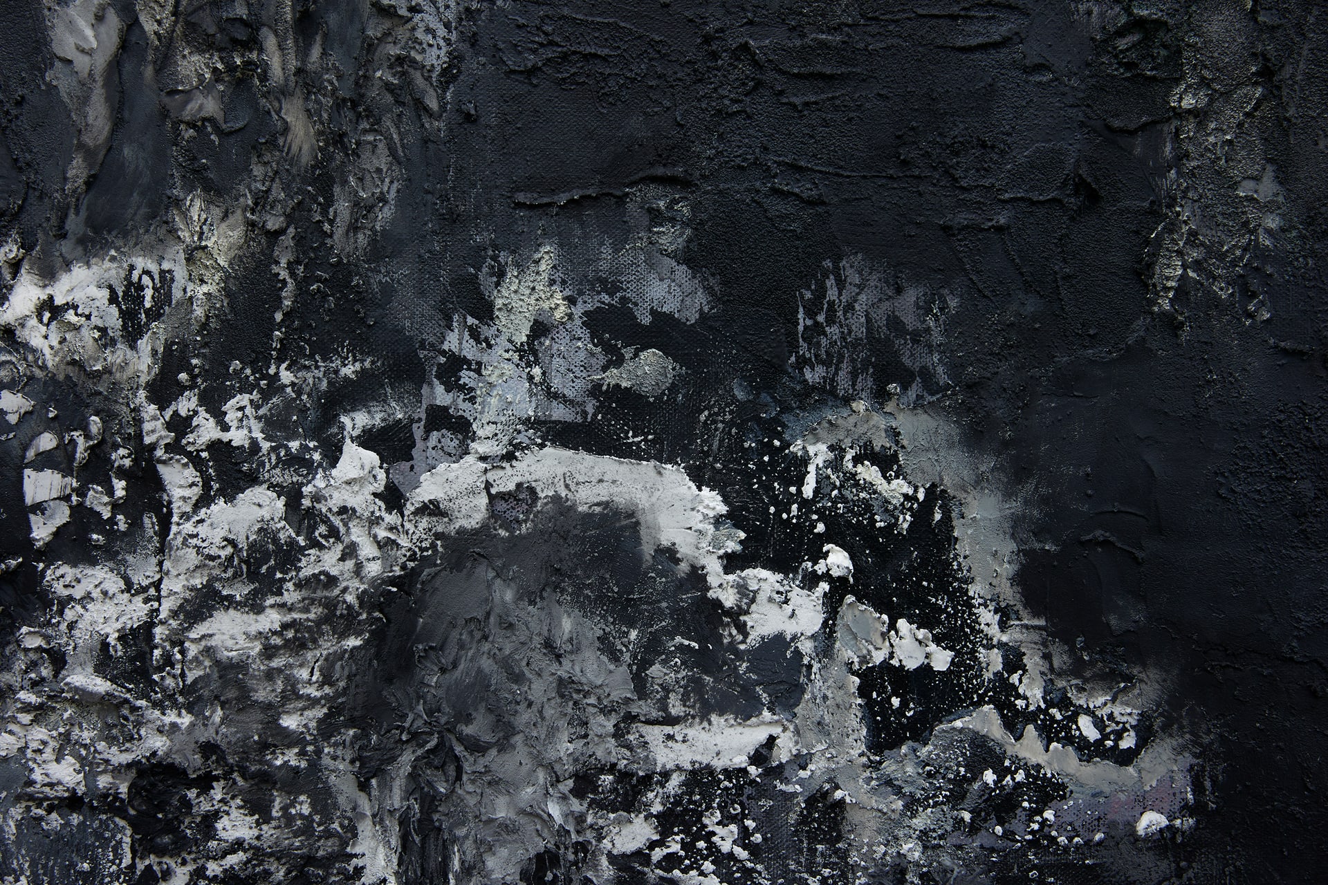 A close-up detail of a black textured canvas with contours. The bottom left of the detail has foamy surface qualities.