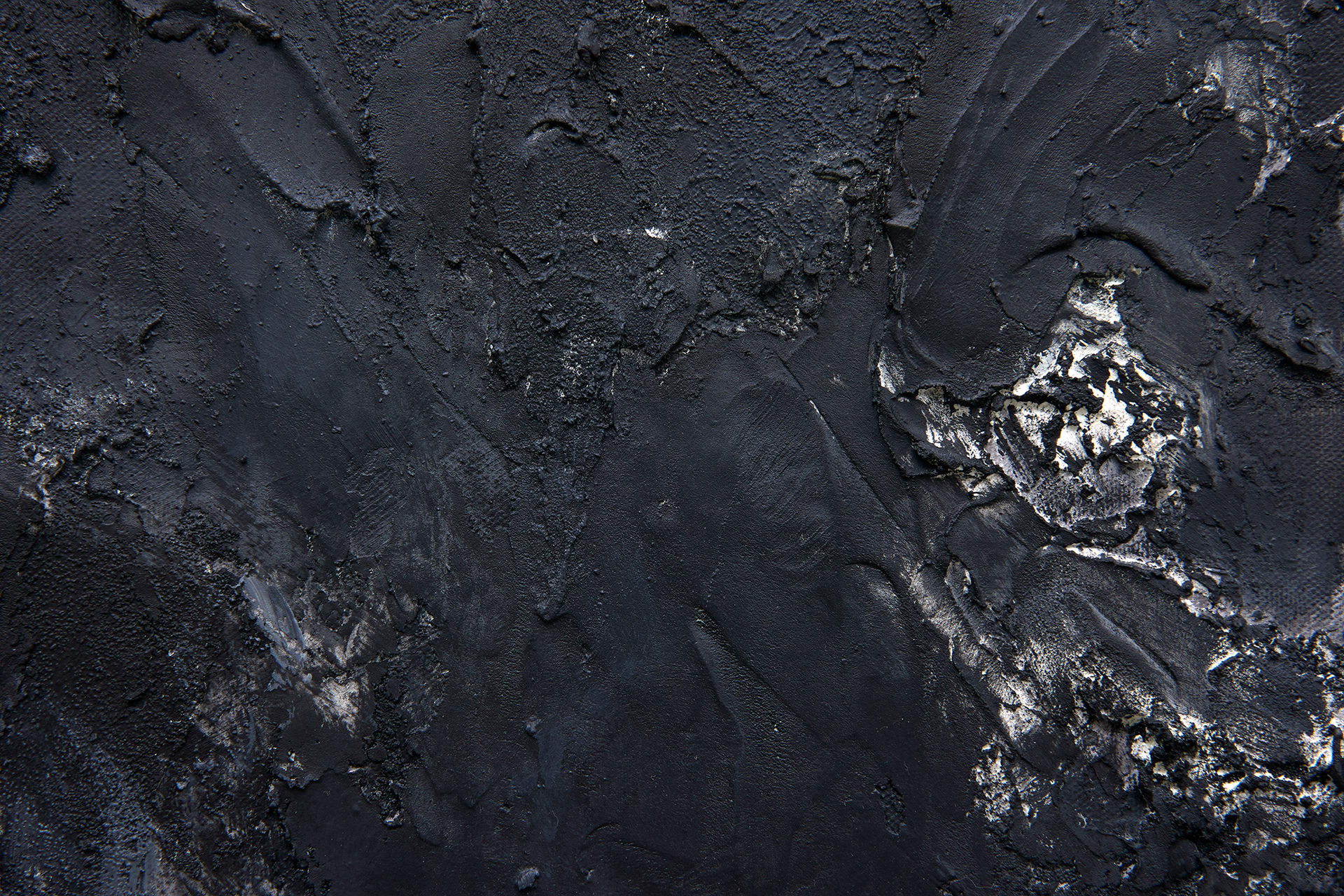 A close-up detail of a black textured canvas with contours.