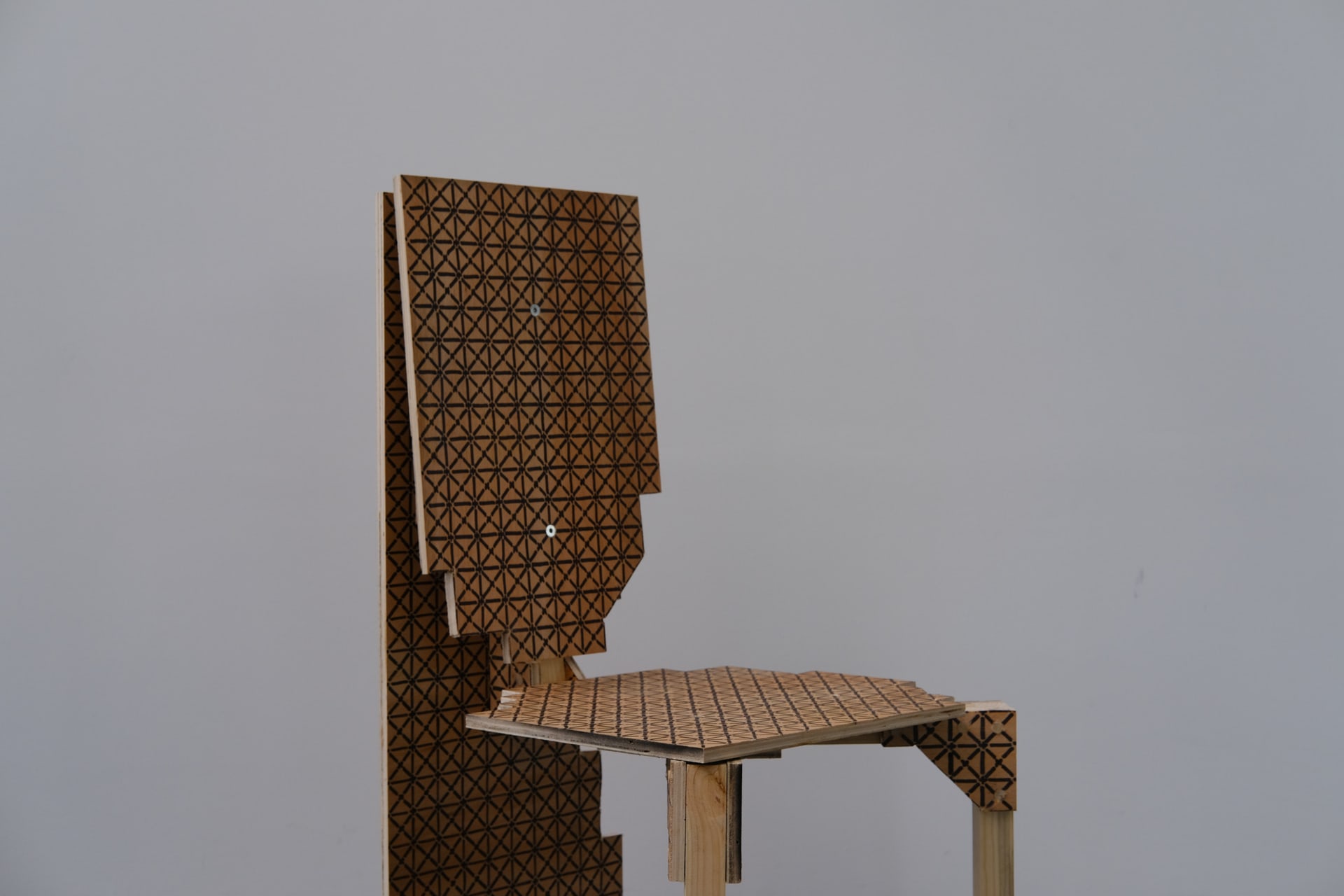 A chair which had a joint cut from grid patterned surface seat, backrest, and back plate