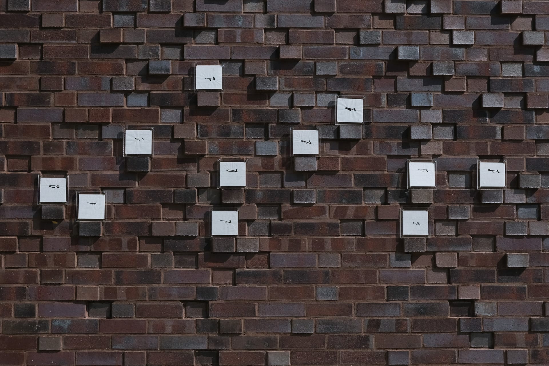 Shows the author's collection of 100 different people writing hello in ink on a mobile phone keyboard via brushes.