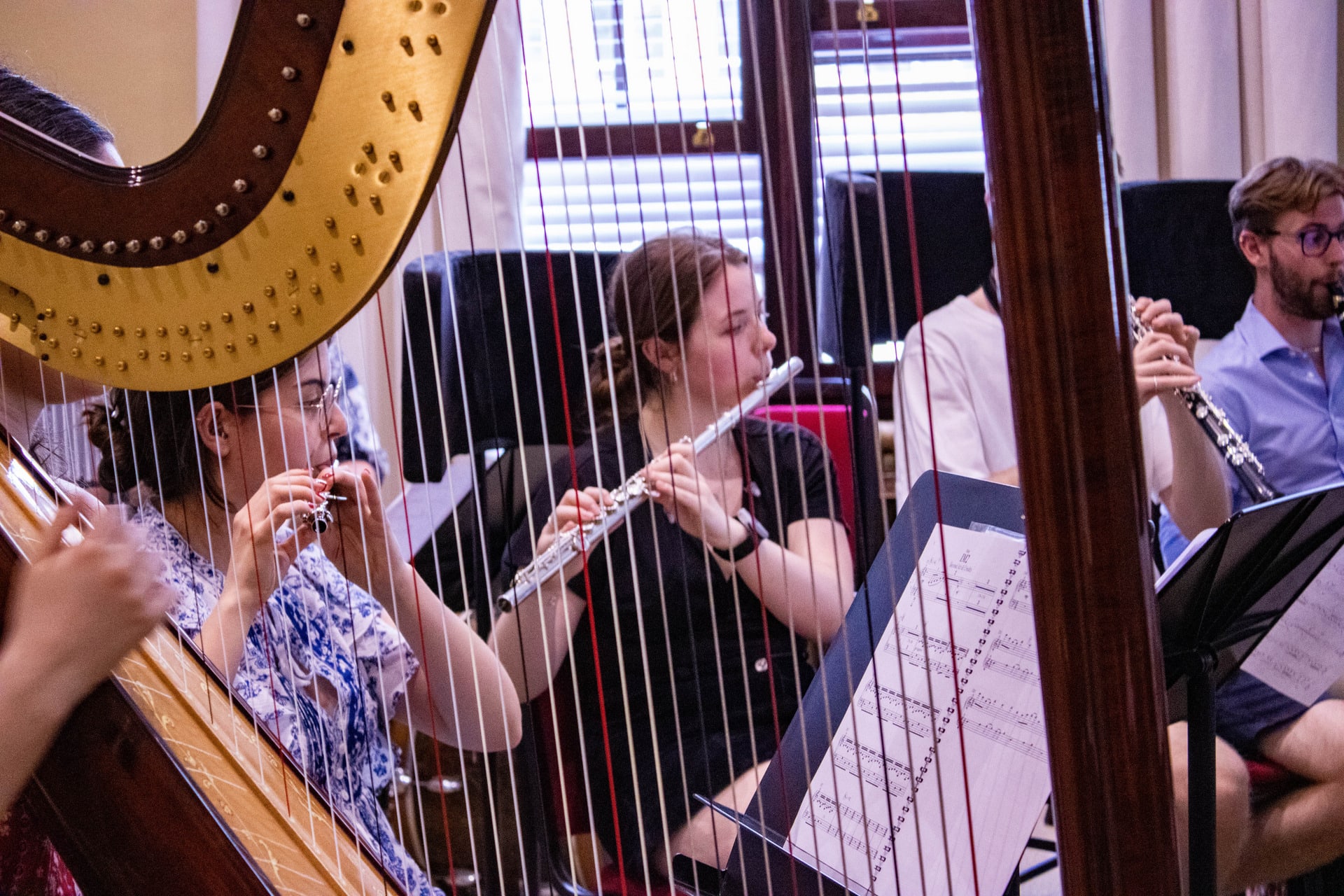 Harp and flutists at music rehearsal