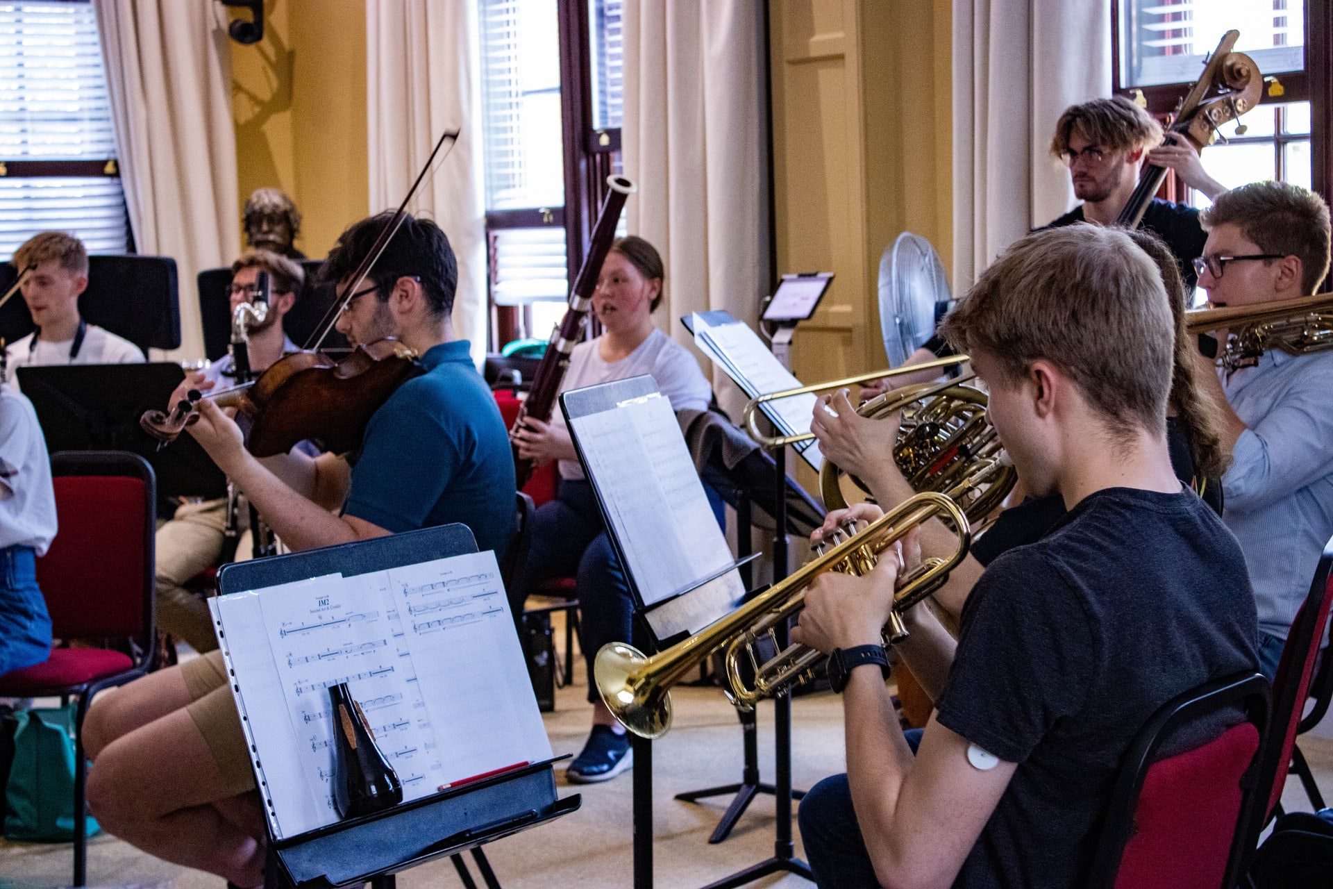 Trumpets and violinists at music rehearsal