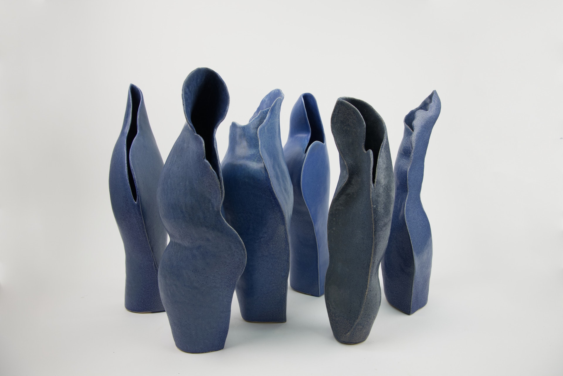 6 curved blue ceramic vessels