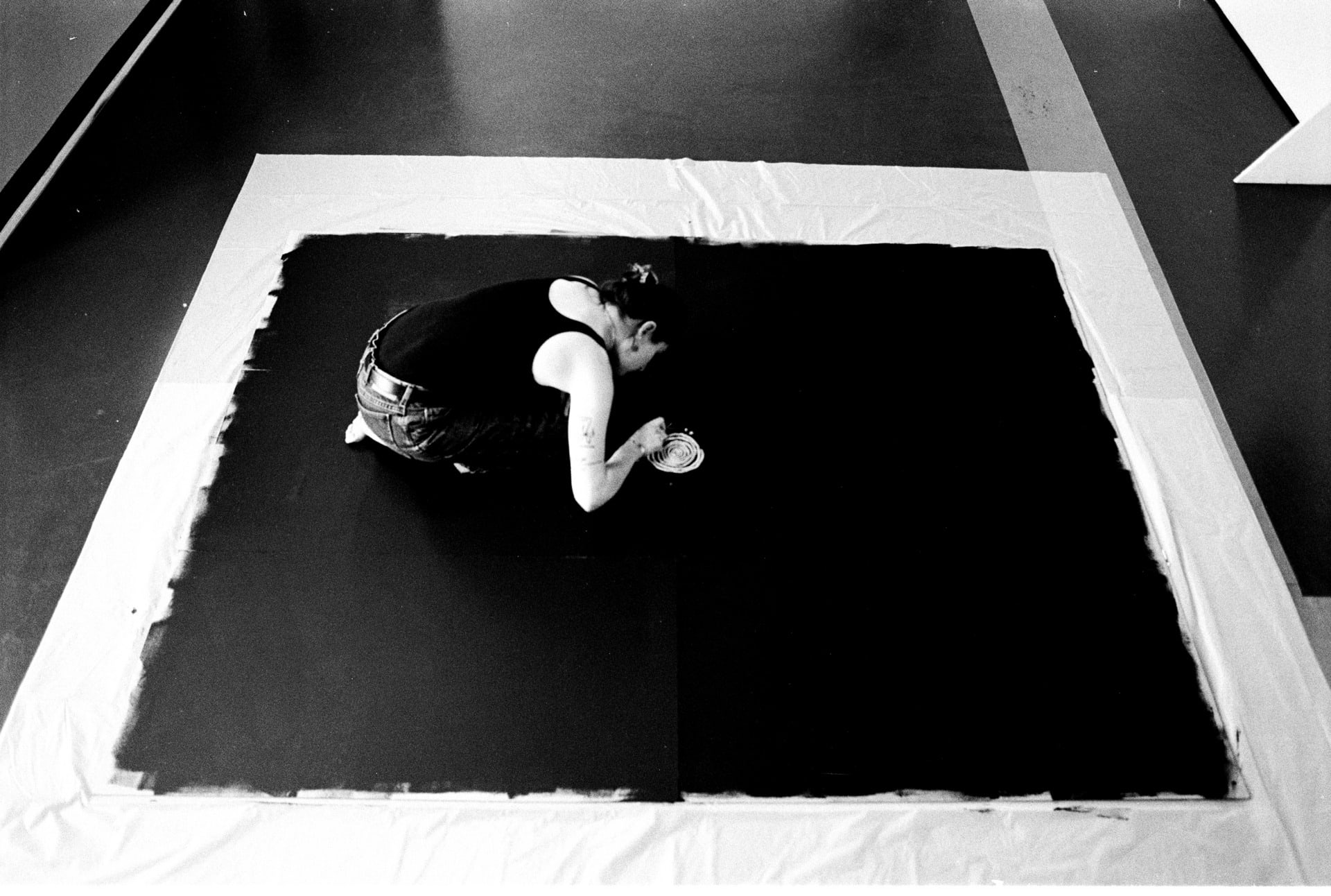 black and white image of the artist, taken from above, shows the artist drawing circles that get progressively bigger 