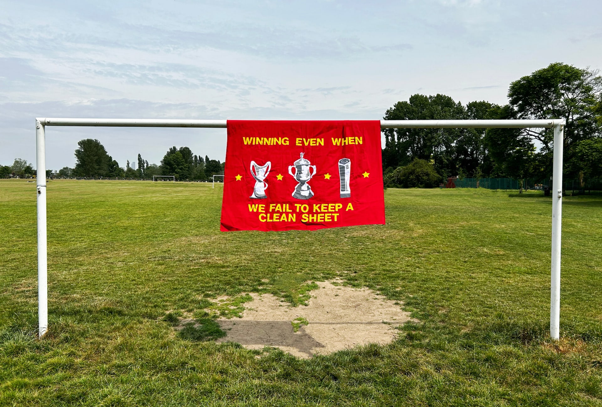 Winning Even When We Fail To Keep A Clean Sheet banner hanging on football goal posts.