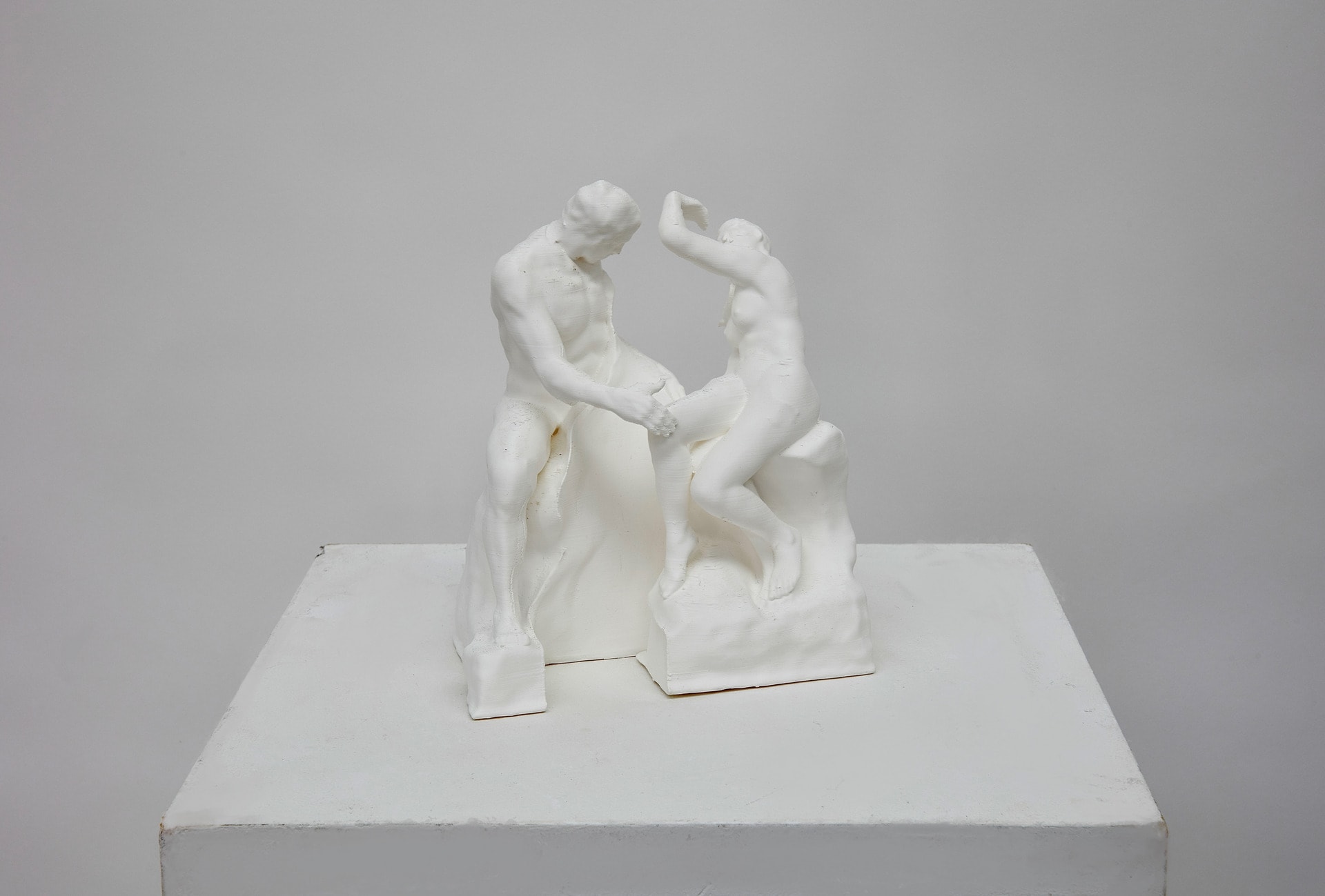 3d printed PLA model of Rodin's "The Kiss" sculpture cut in half where the two lovers' bodies touch, separating them. 