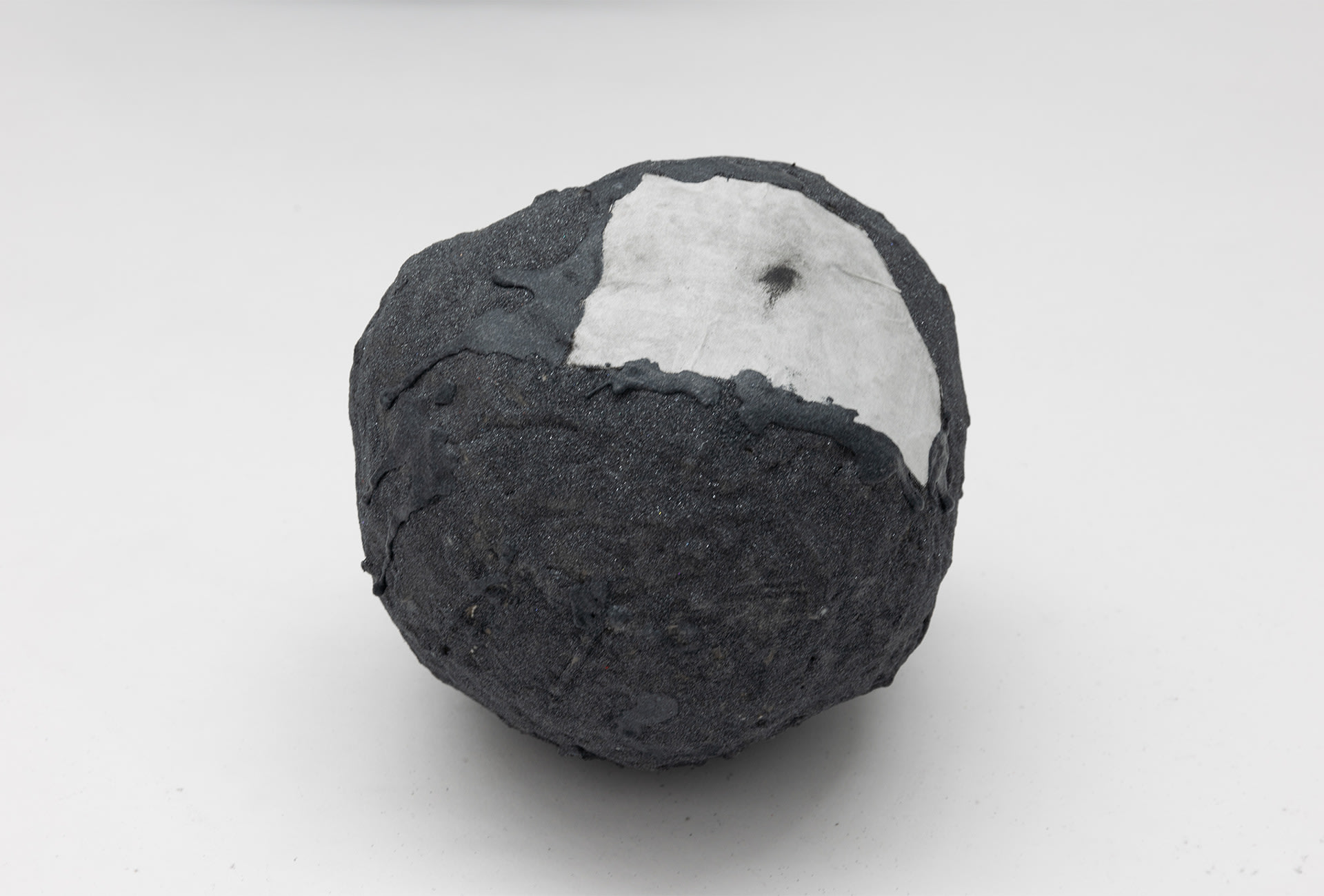 Small boulder with a lithograph of a bottom belly glued on its surface