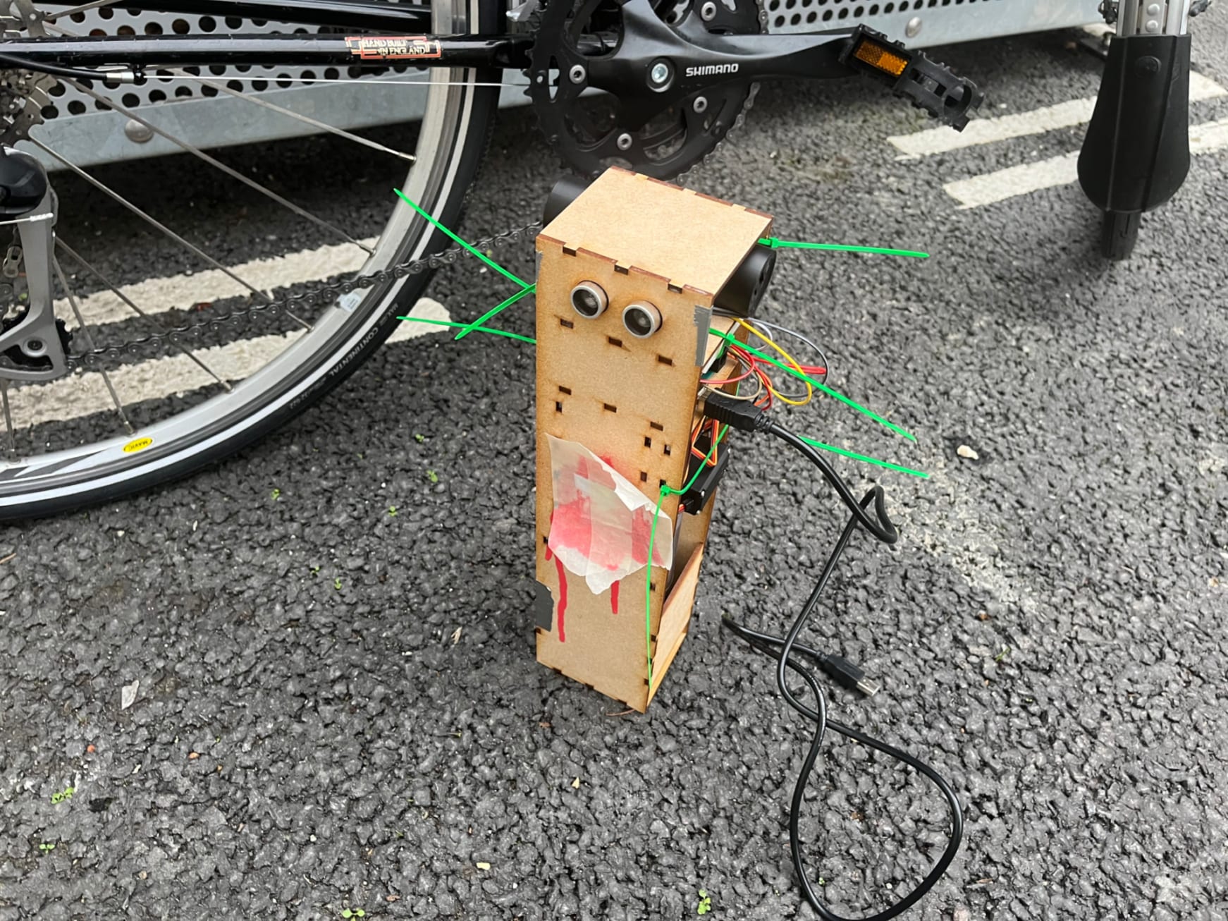 A laser cut MDF robot, with many visible arduino wires and cable ties.