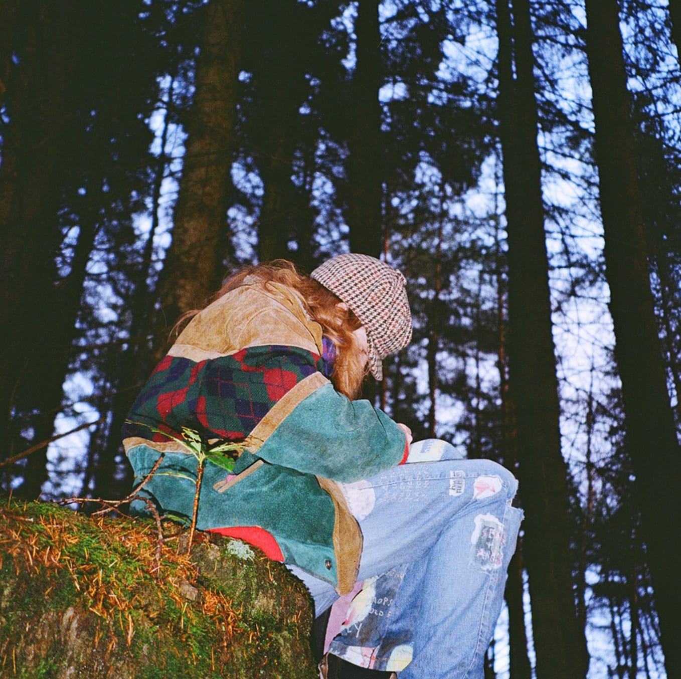 Image of artist sitting in a forest at dusk.