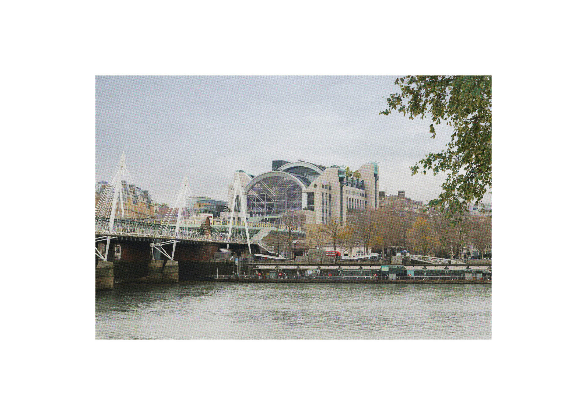 A circular opening seen from across the river is seemingly cut out from the façade