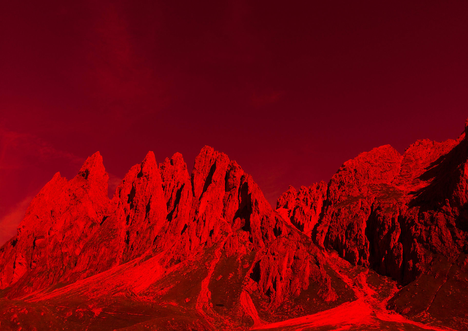a picture of red mountains, the Dolomites in northern Italy, with a bright red filter over the image.