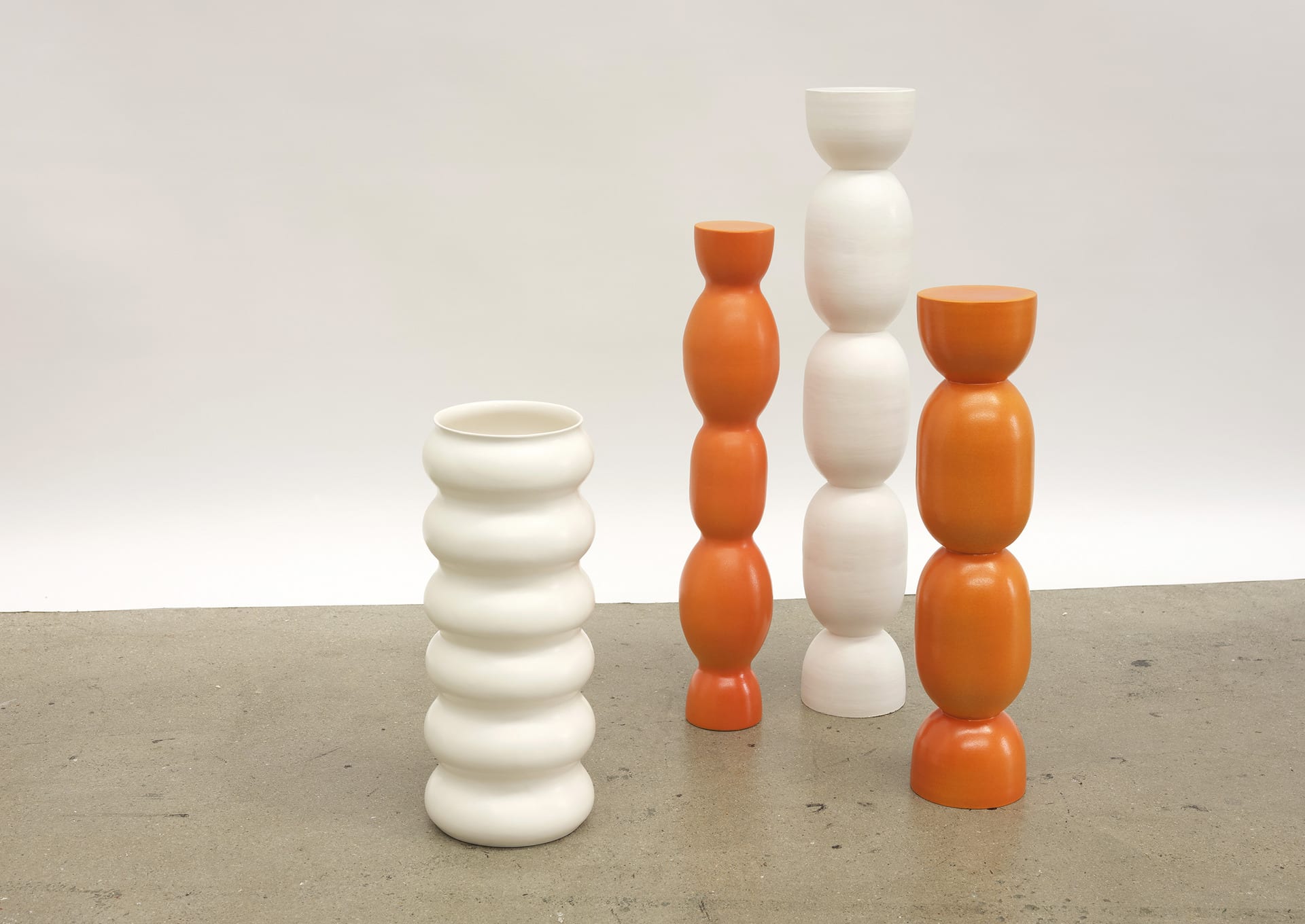 Wobbly tall vessels of slightly different shapes. Smooth appearance and a shiny surface