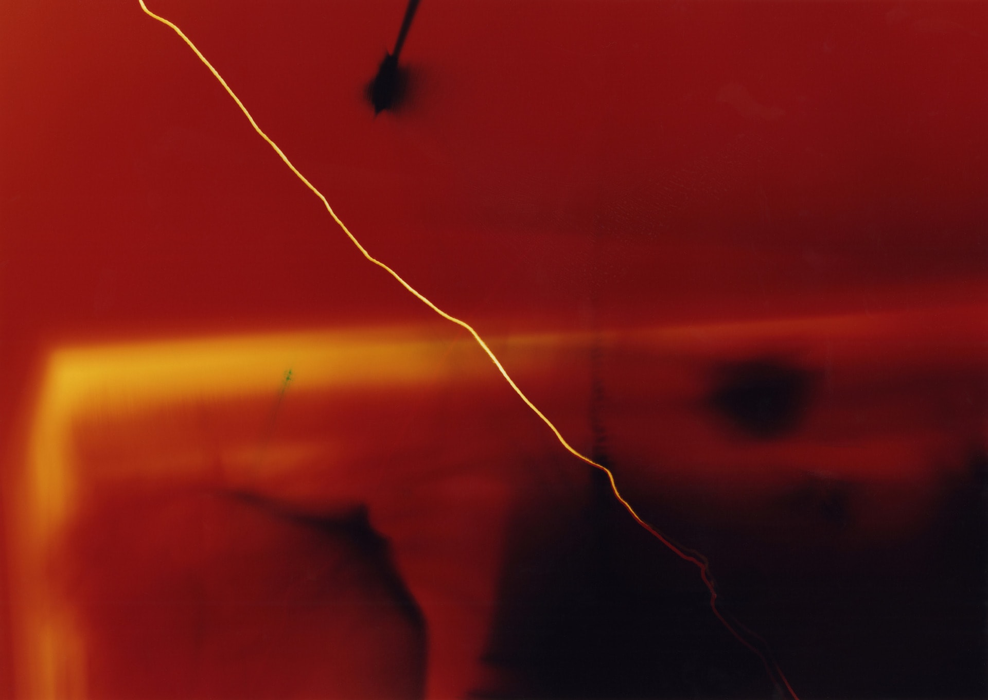 Red photogram with flashes of yellow and black formless shapes