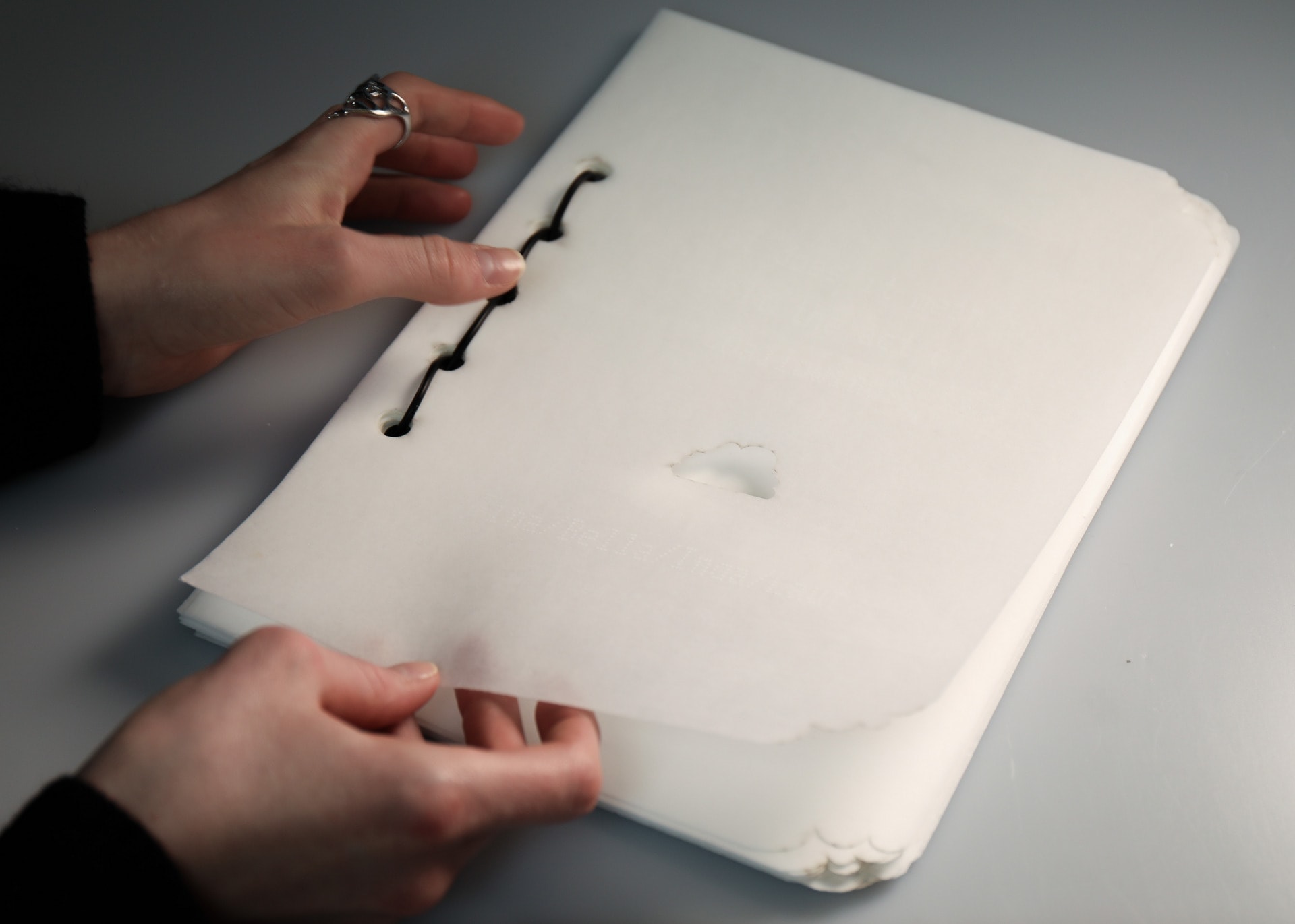 Photograph of front cover of edible book showing cloud shape cut out and electrical wire binding