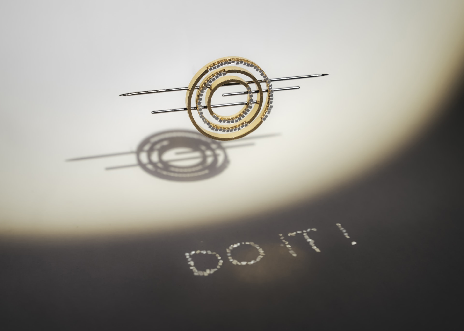 The light is reflected on the paper through the reflective surface of the jewellery to show the words "do it"