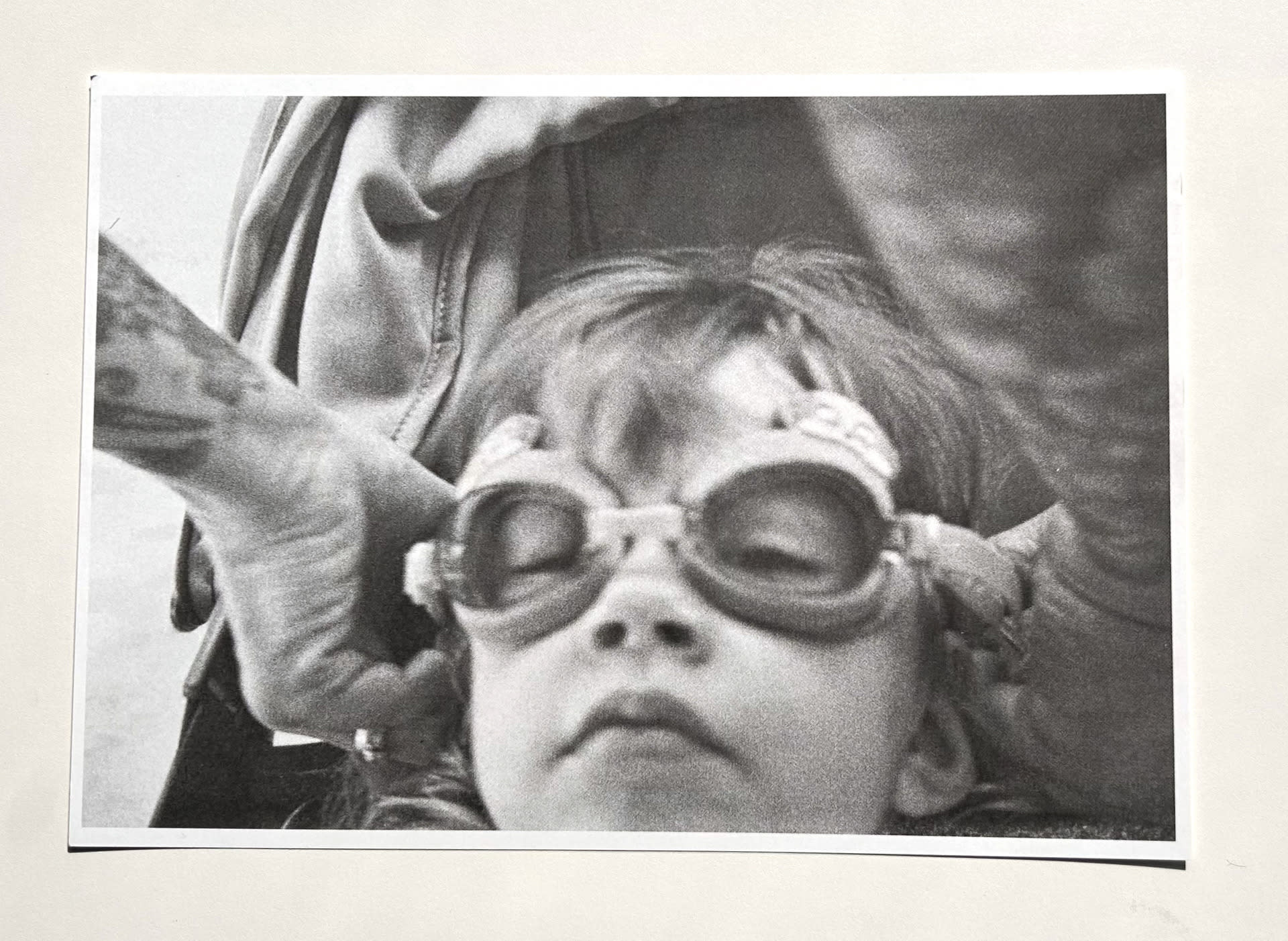 Mother helps her daughter get her swimming goggles on