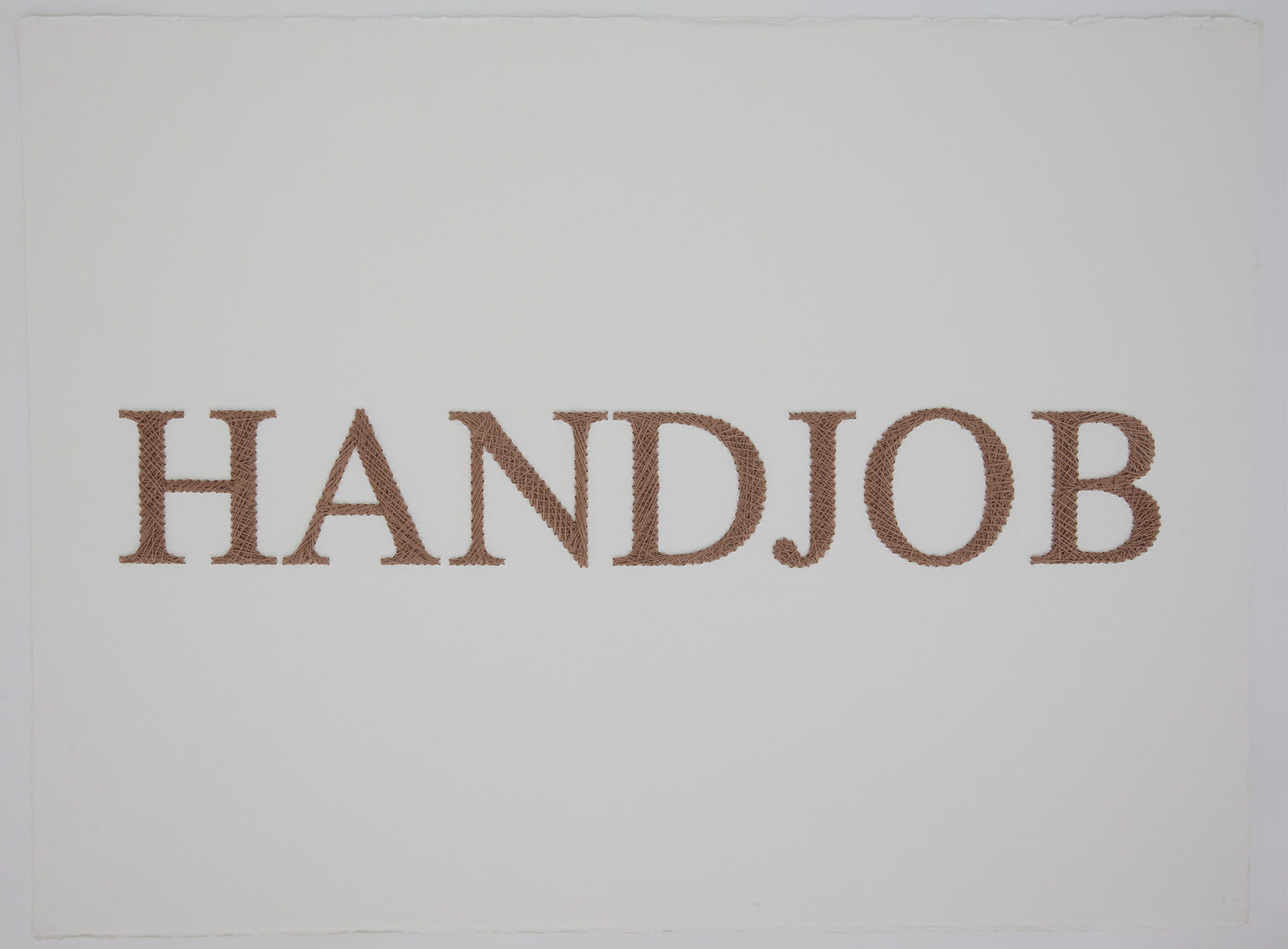 The word "handjob" embroidered on paper