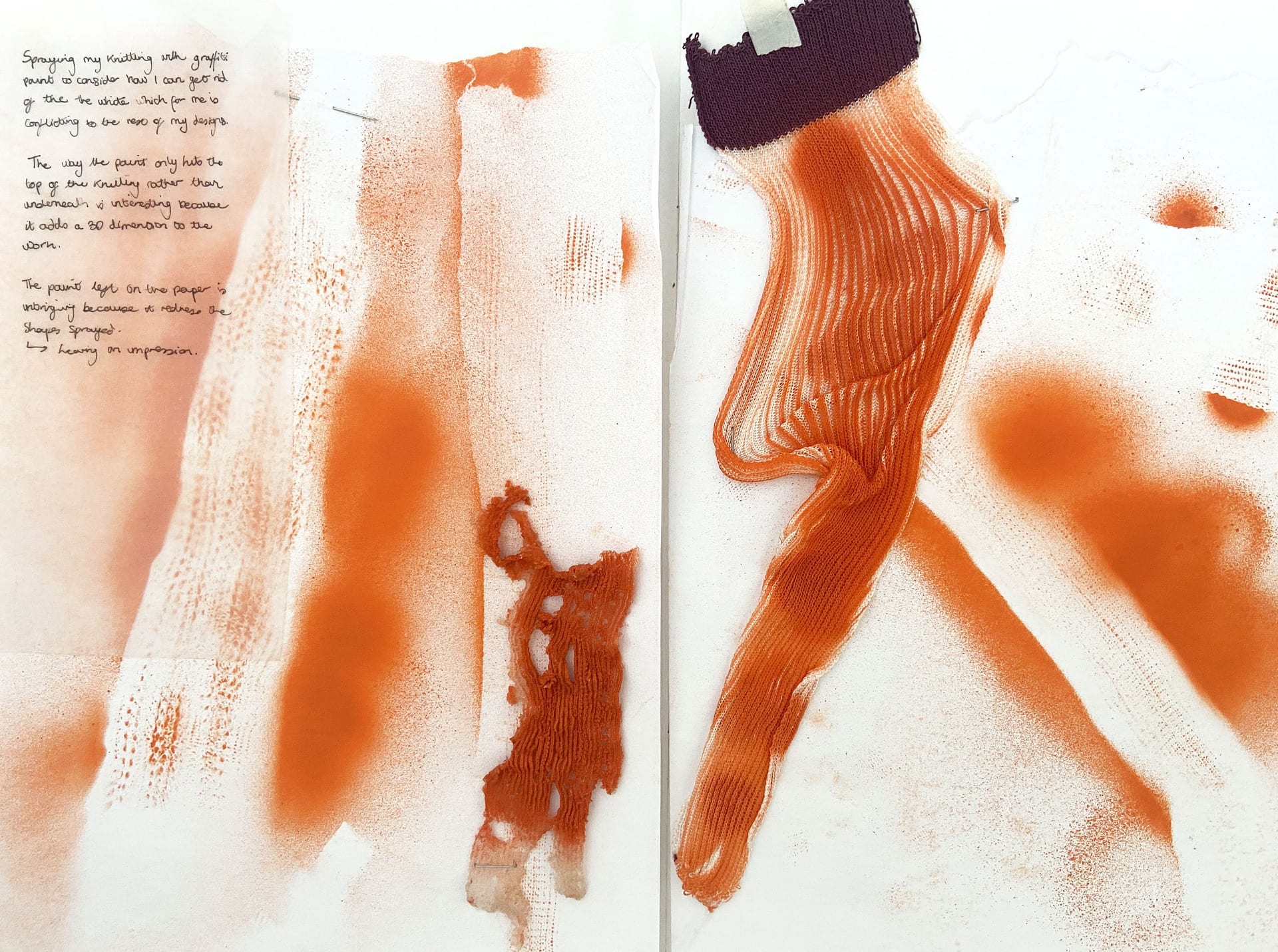 Sketchbook with a dissolvable yarn sample with orange spray paint on top.