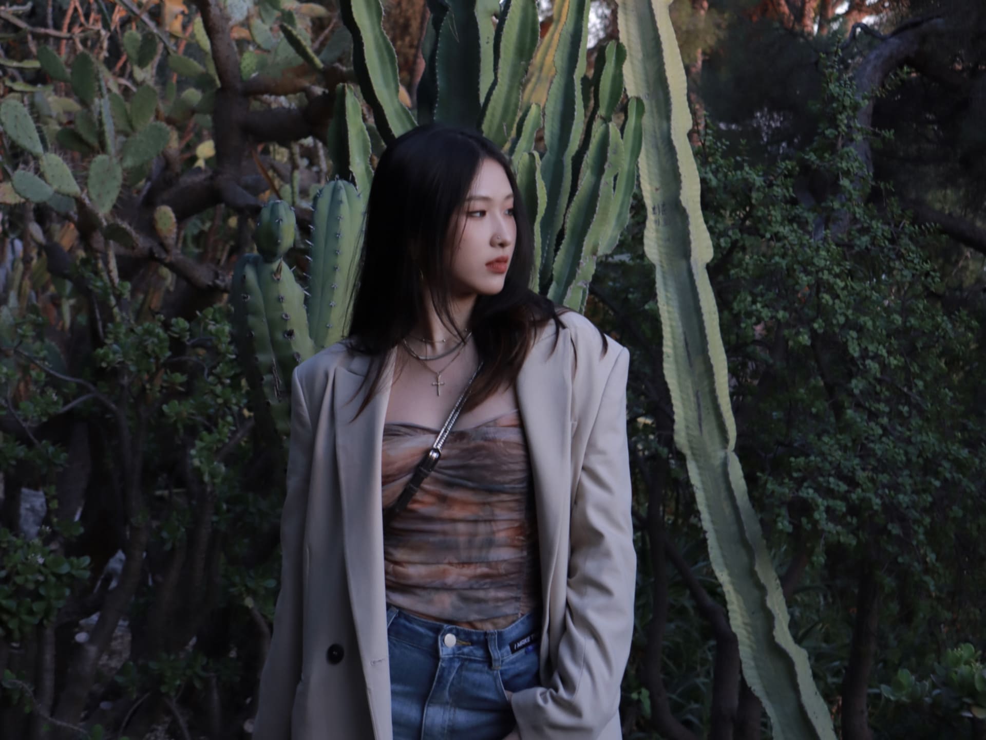 A girl standing sideways in front of a tree