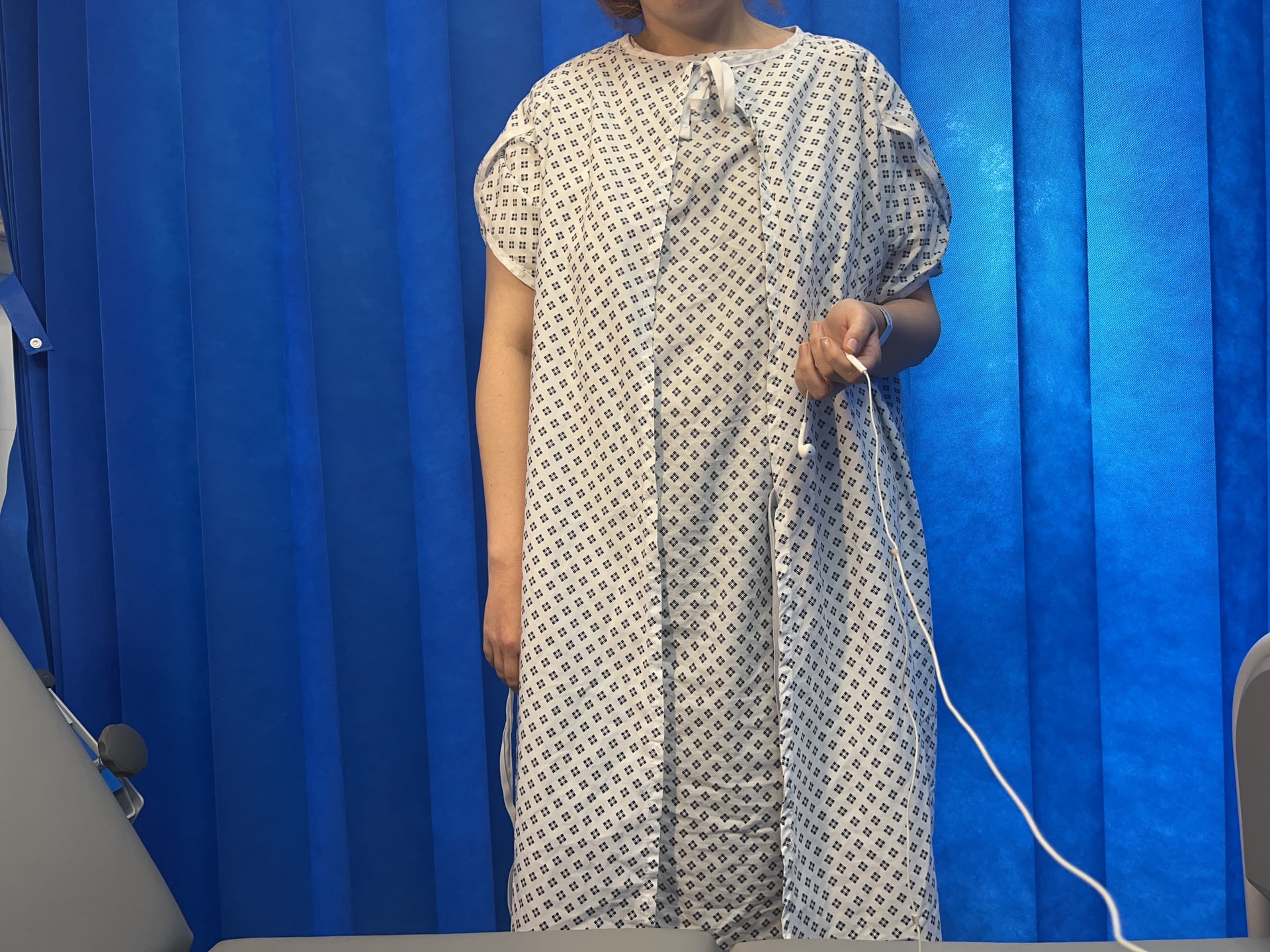 girl in hospital gown using headphones as a remote shutter