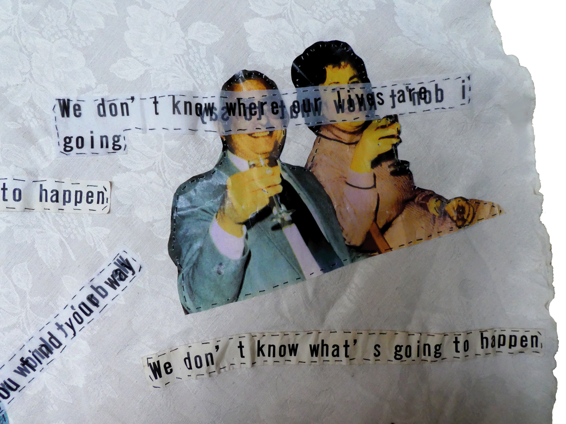 Tablecloth detail - hand-stitched text and image of couple with glasses raised and text stitched over their eyes