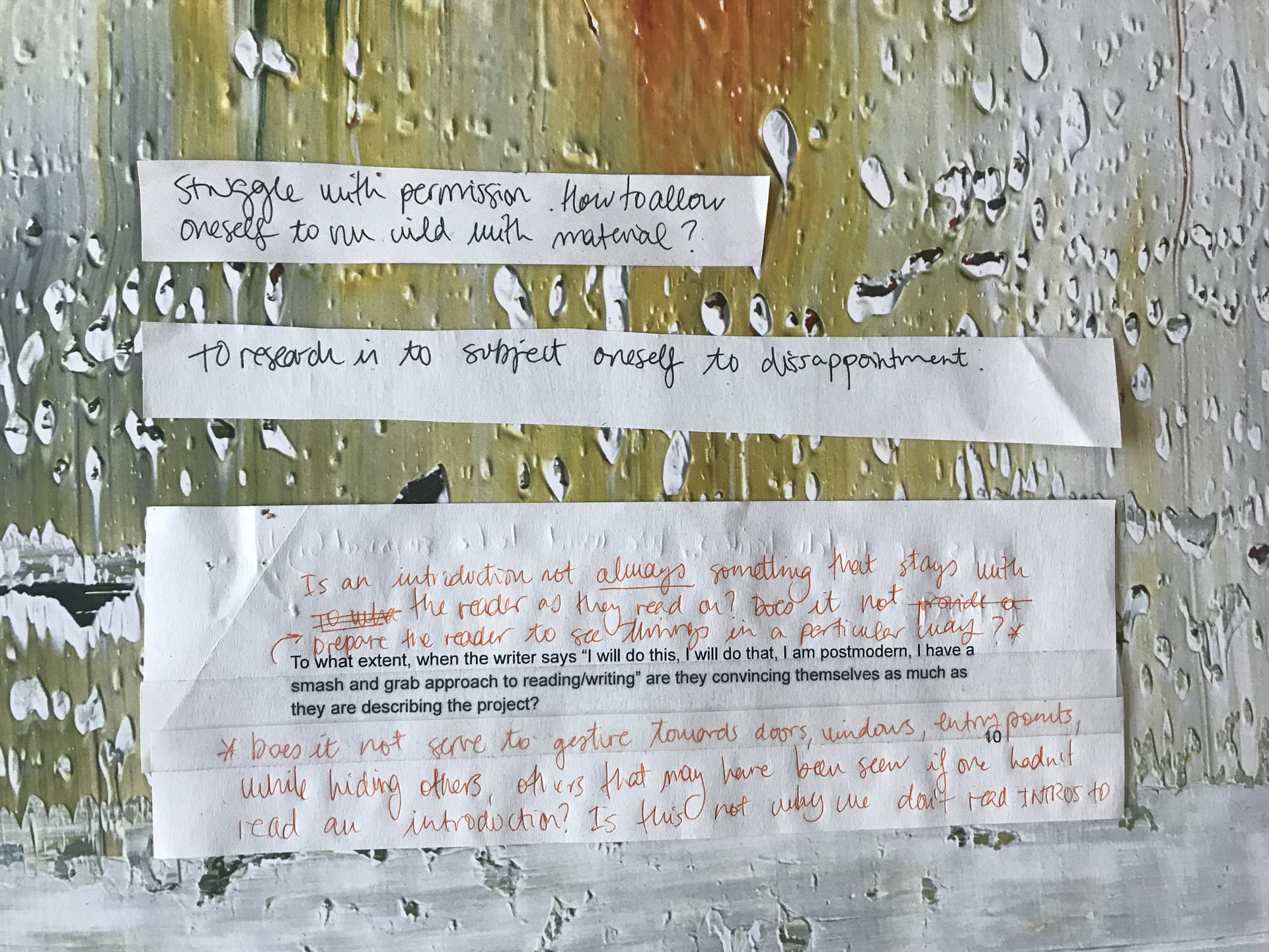 Three snippets of paper on a messy painted background